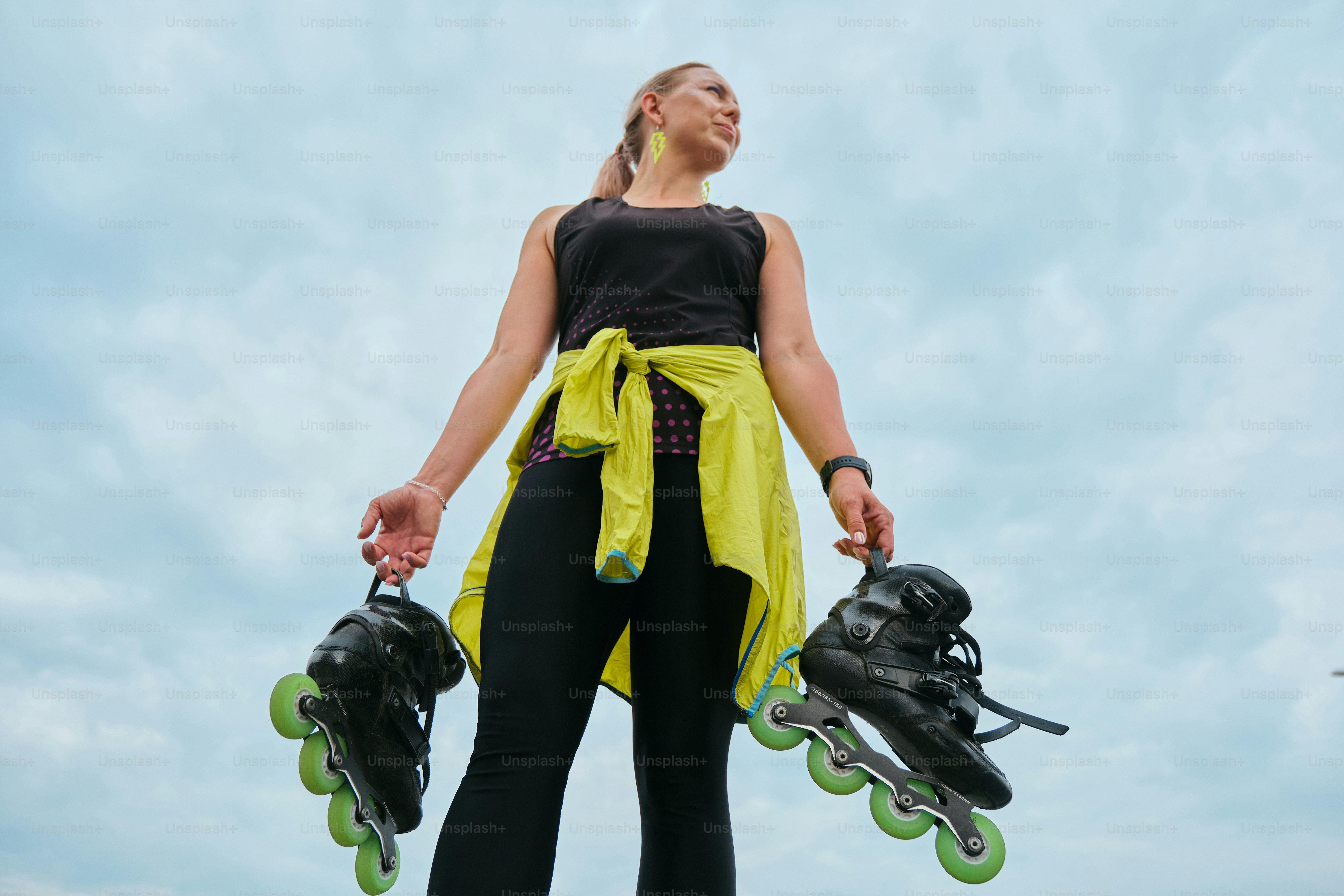 Woman poses with inline skates, looking away