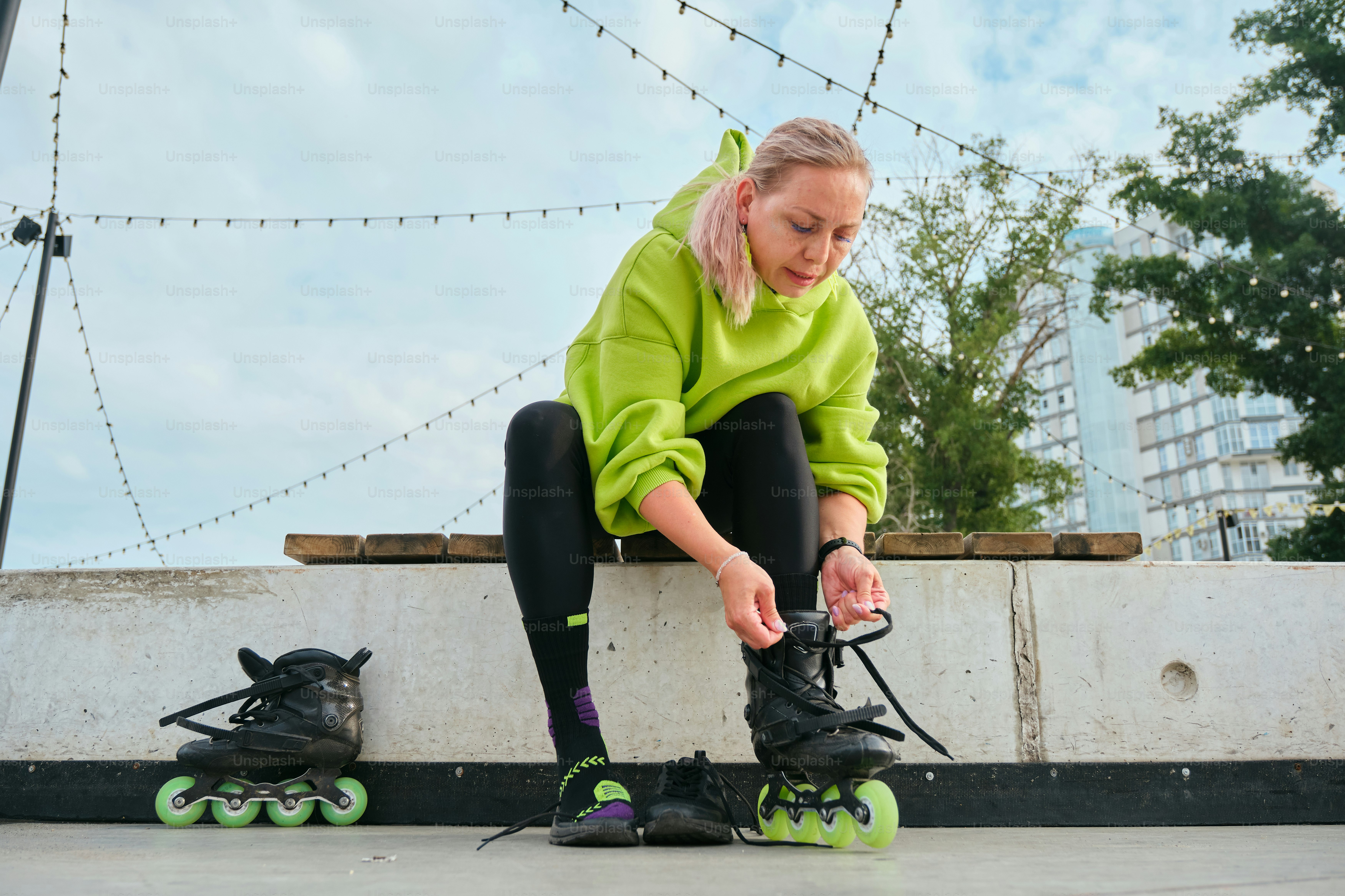 Woman laces up her inline skates before skating