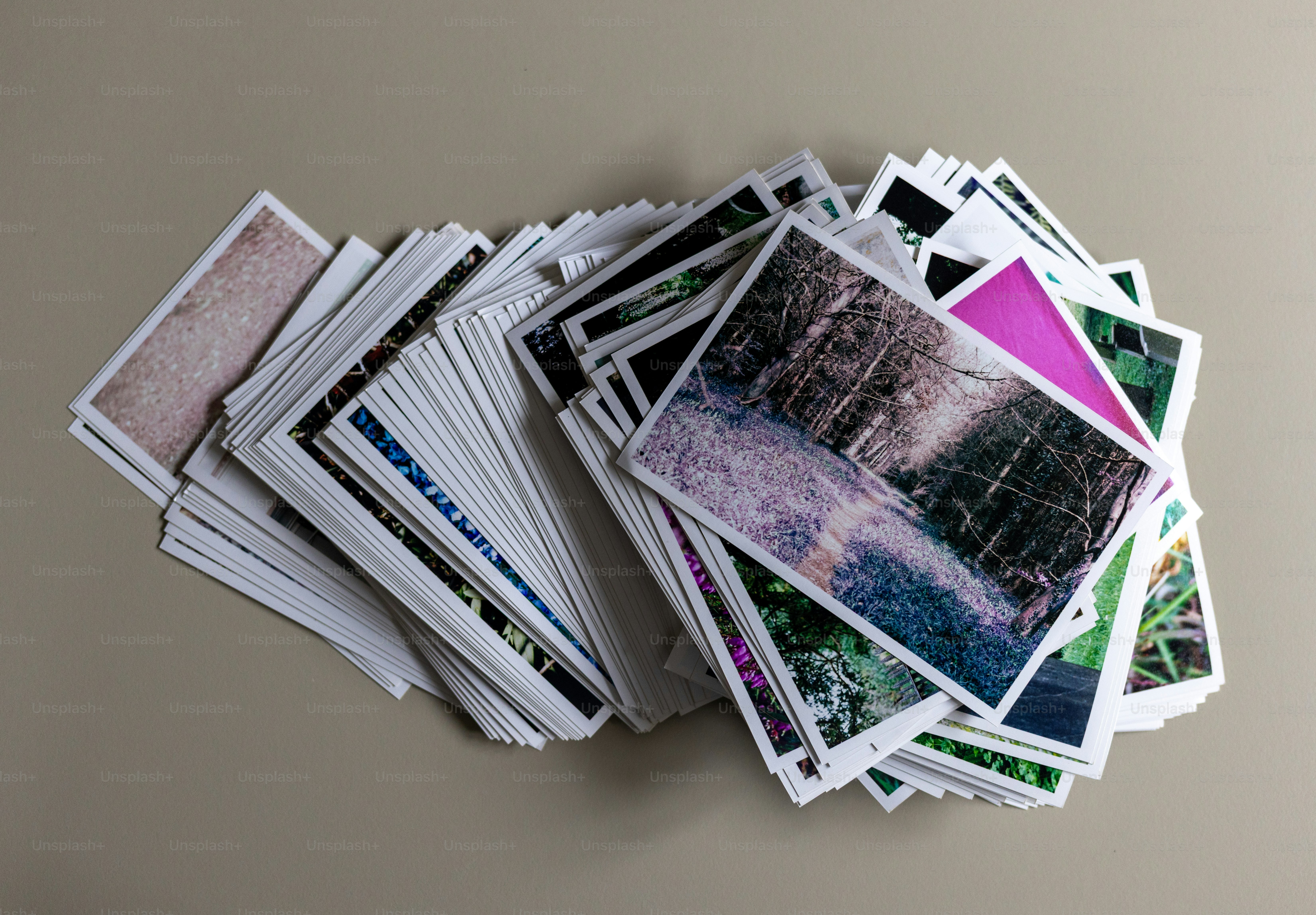 A stack of printed photographs on a table.