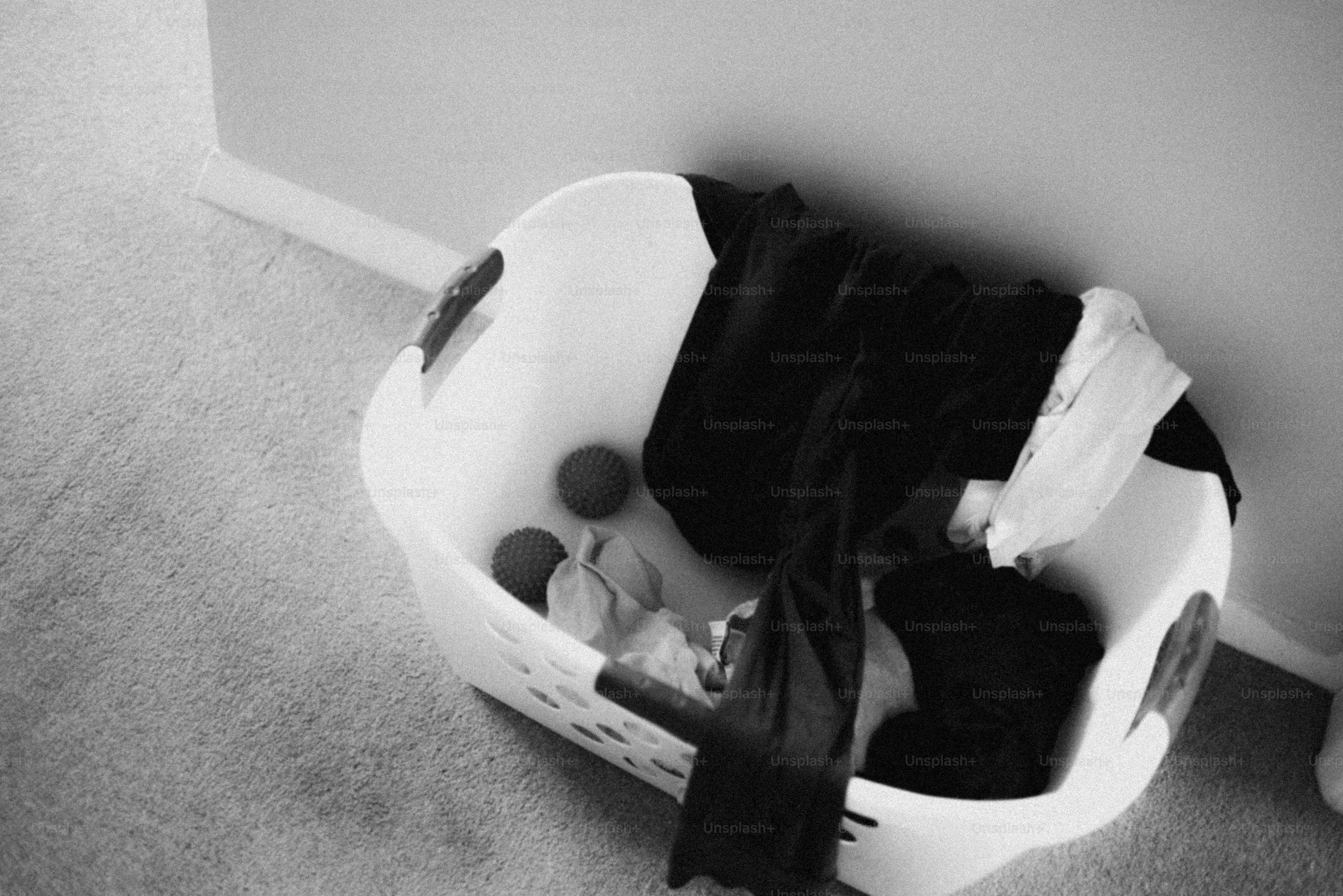 A laundry basket is full of clothes.