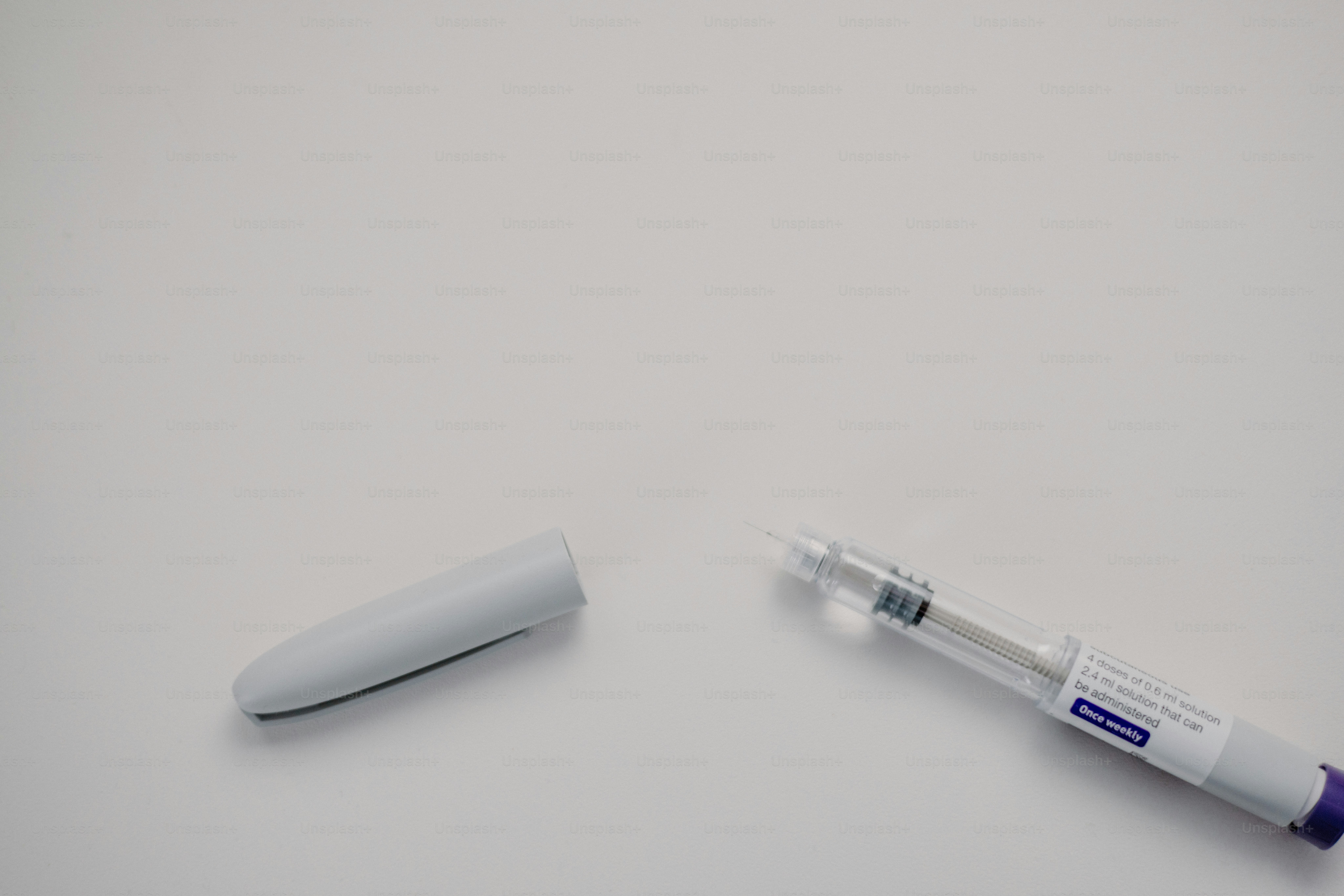 Insulin pen with its cap lying nearby.