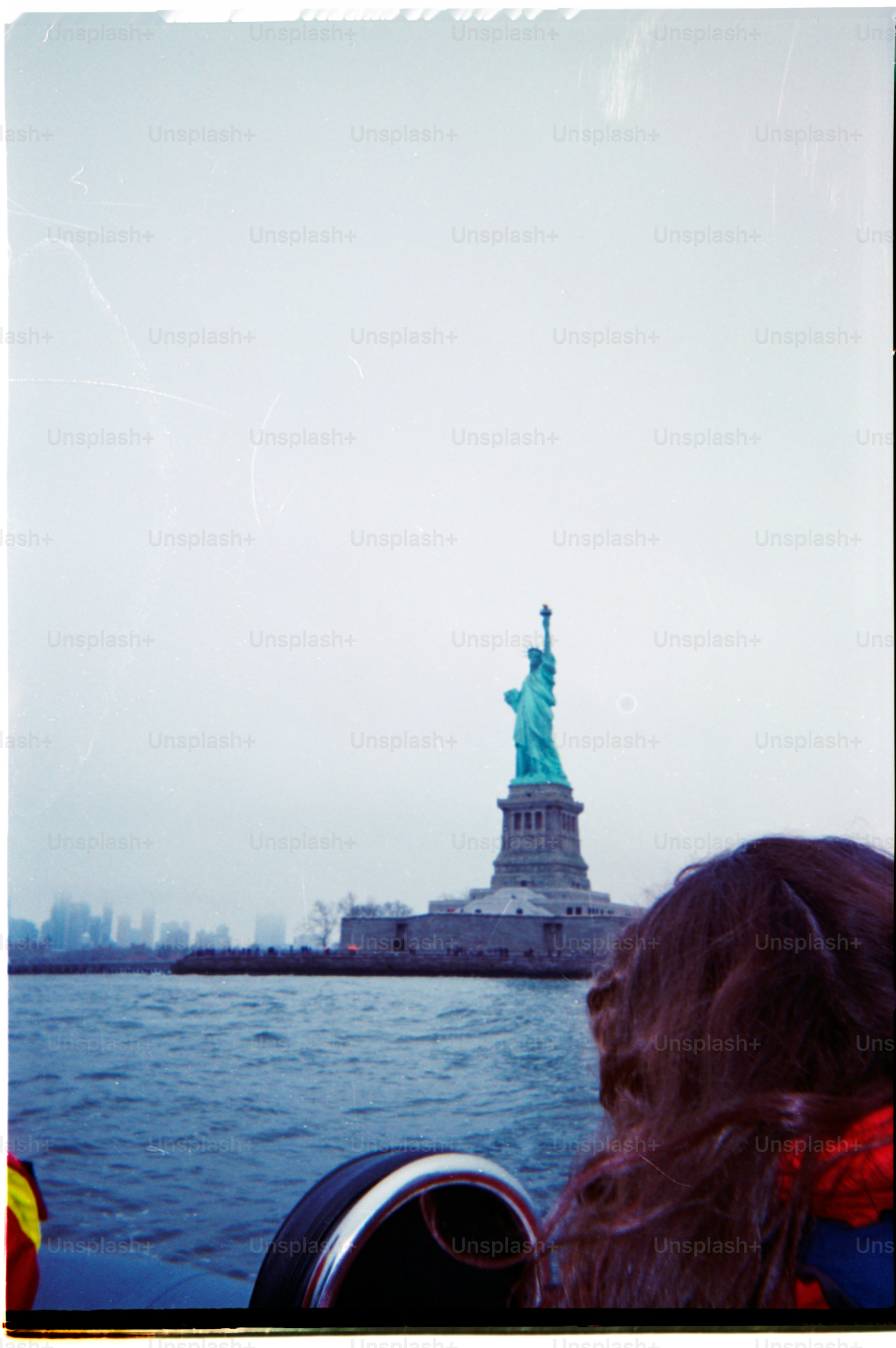 A view of the statue of liberty on the water.
