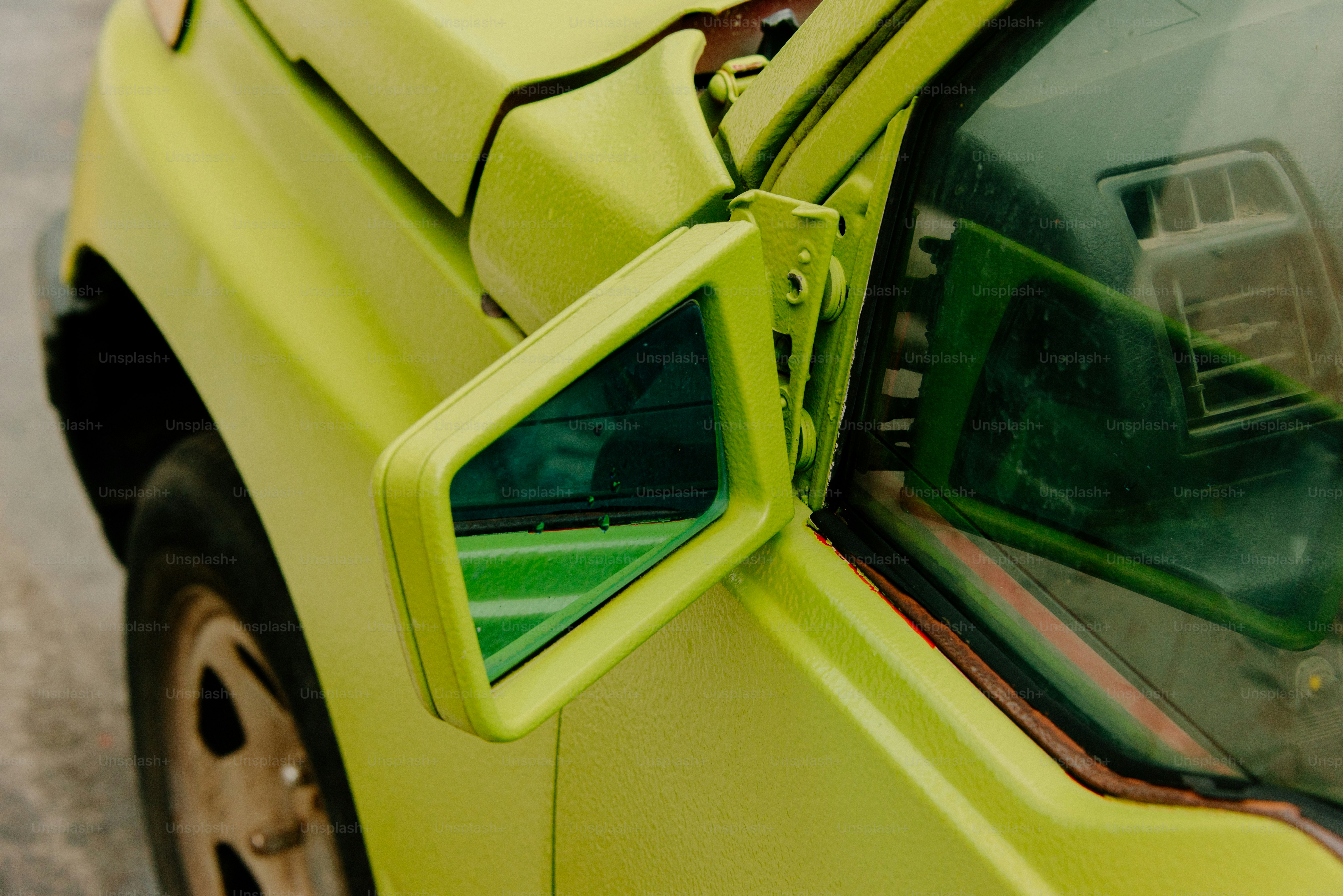 Side mirror of a lime green car.