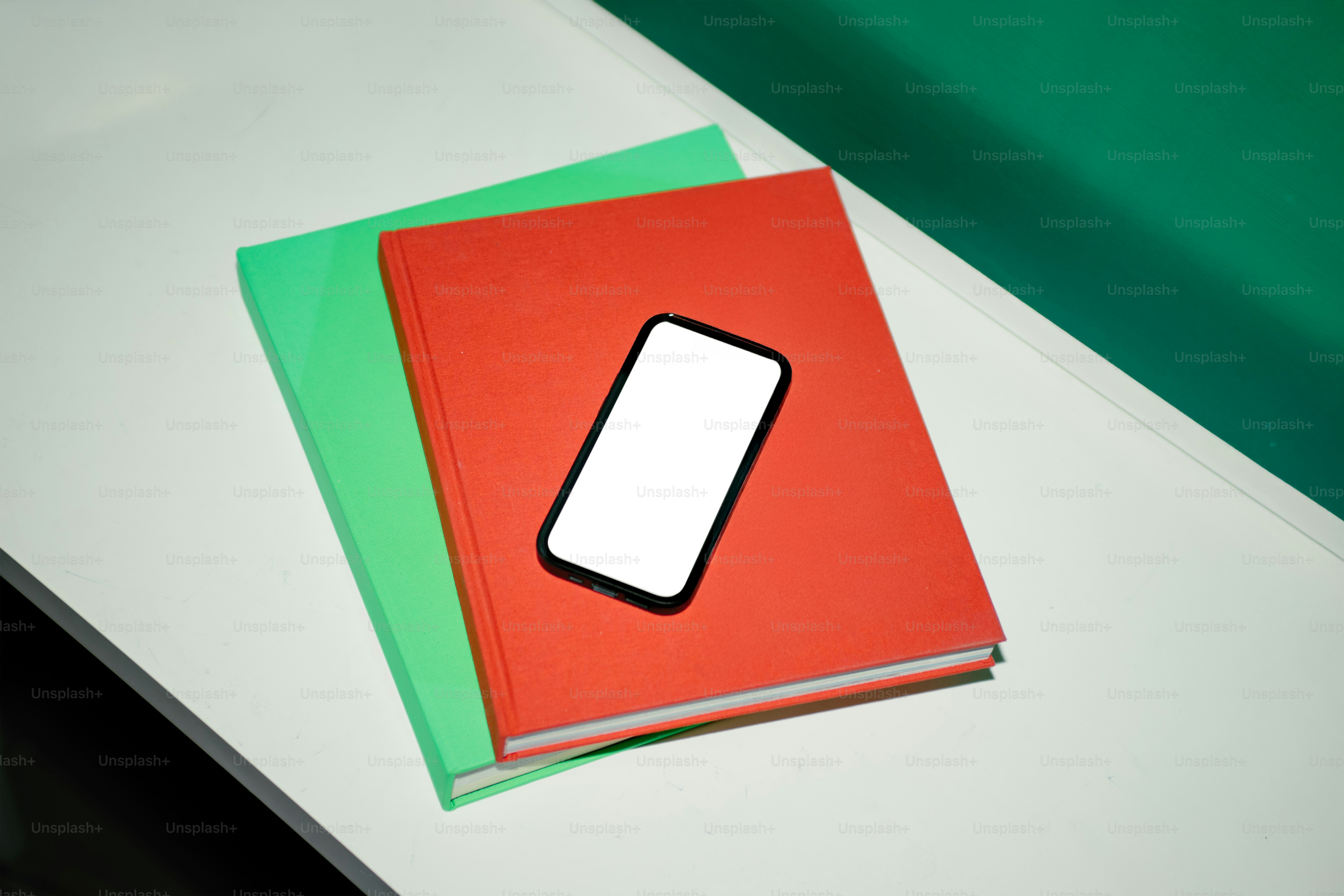 A phone rests on books.