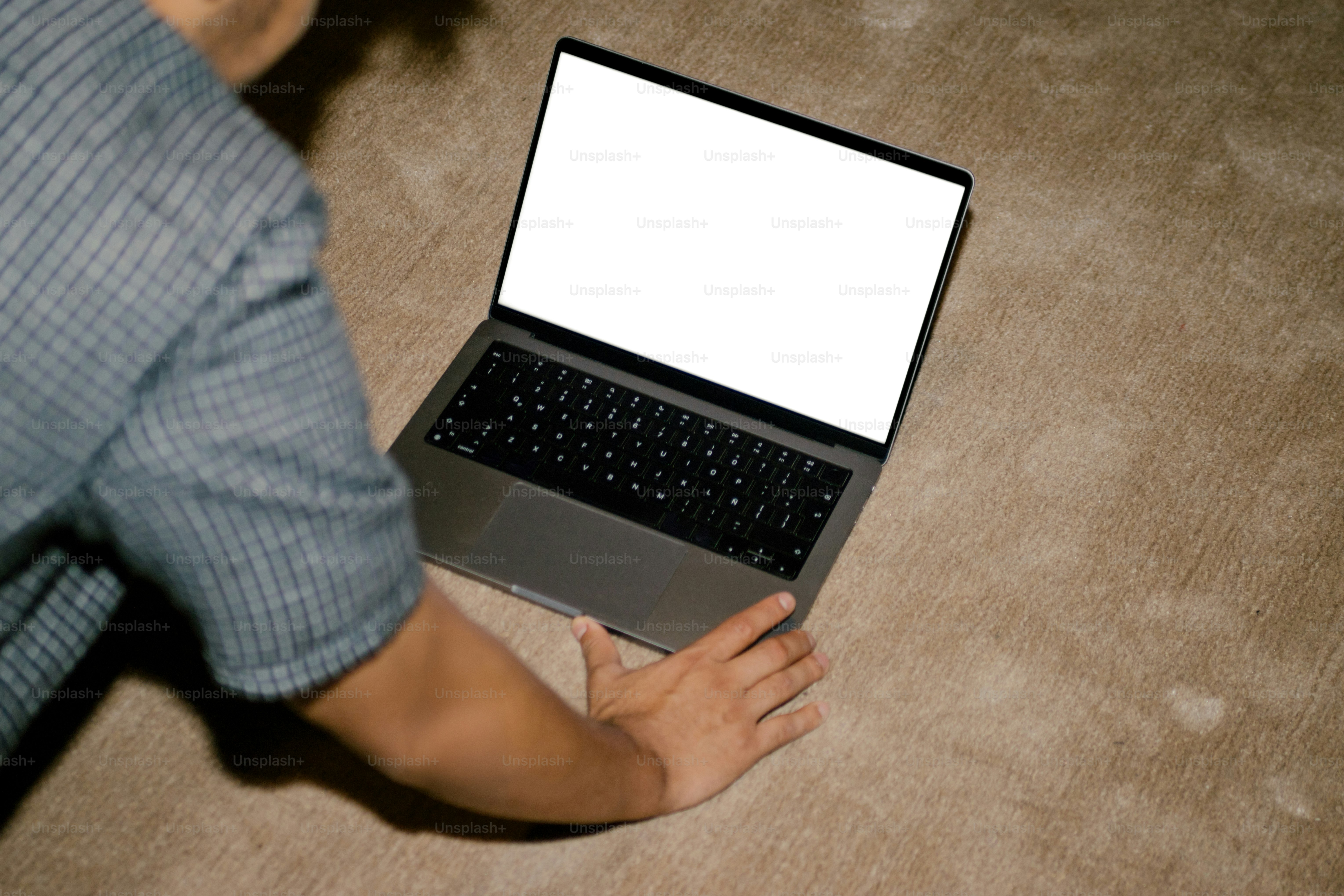 Person looking at an open laptop on the floor.