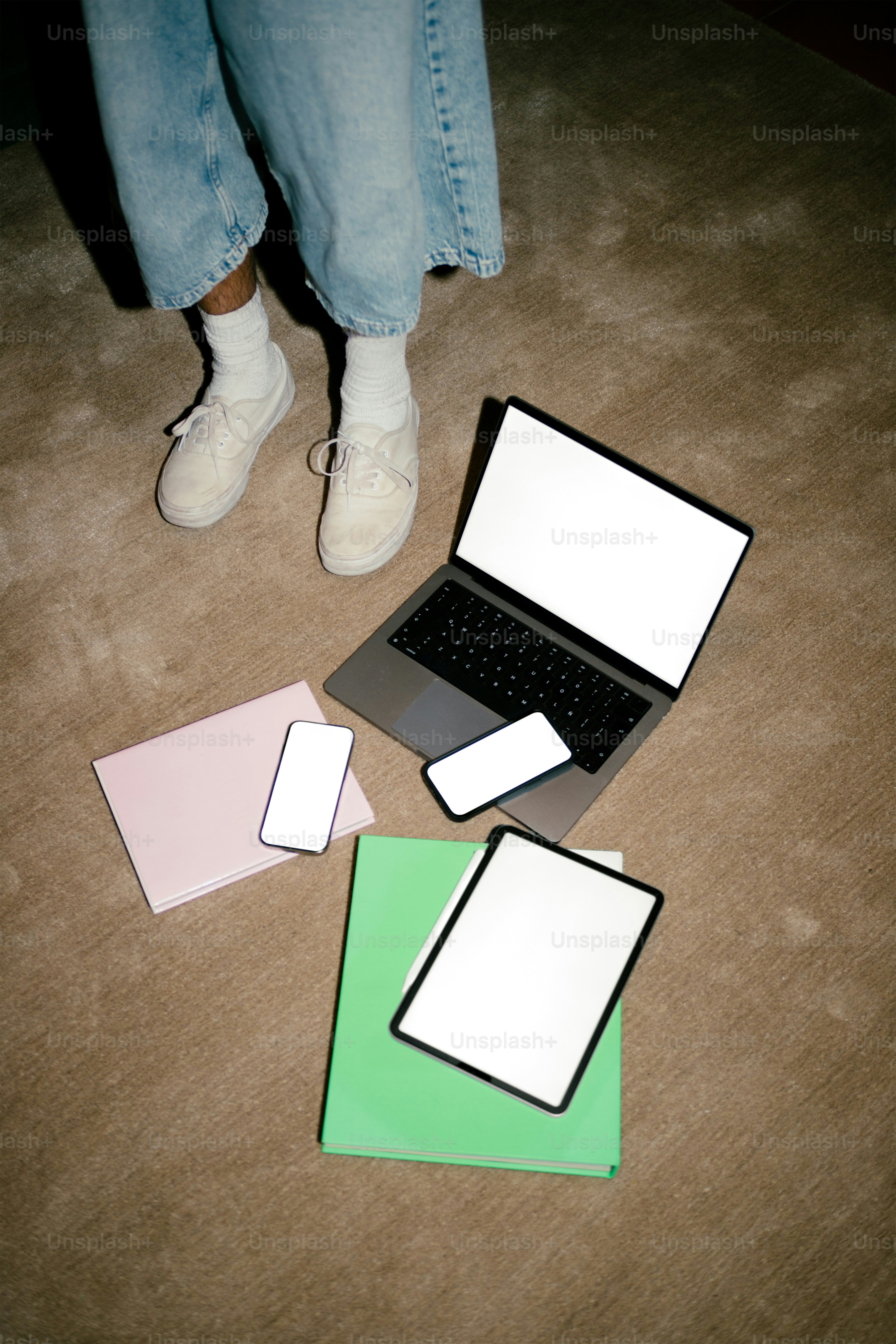 A person stands near various devices and papers.