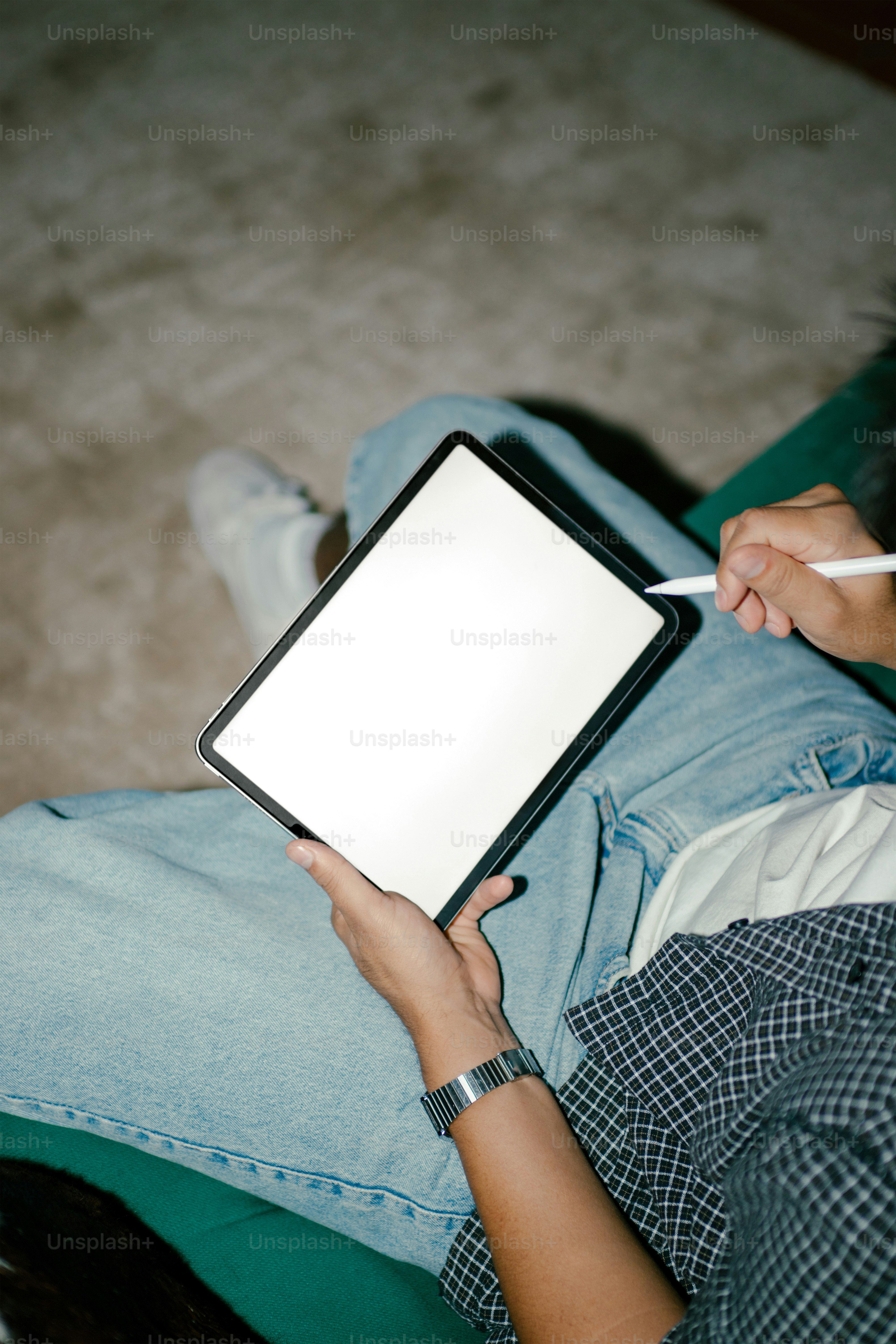 Someone is using a tablet with a stylus.