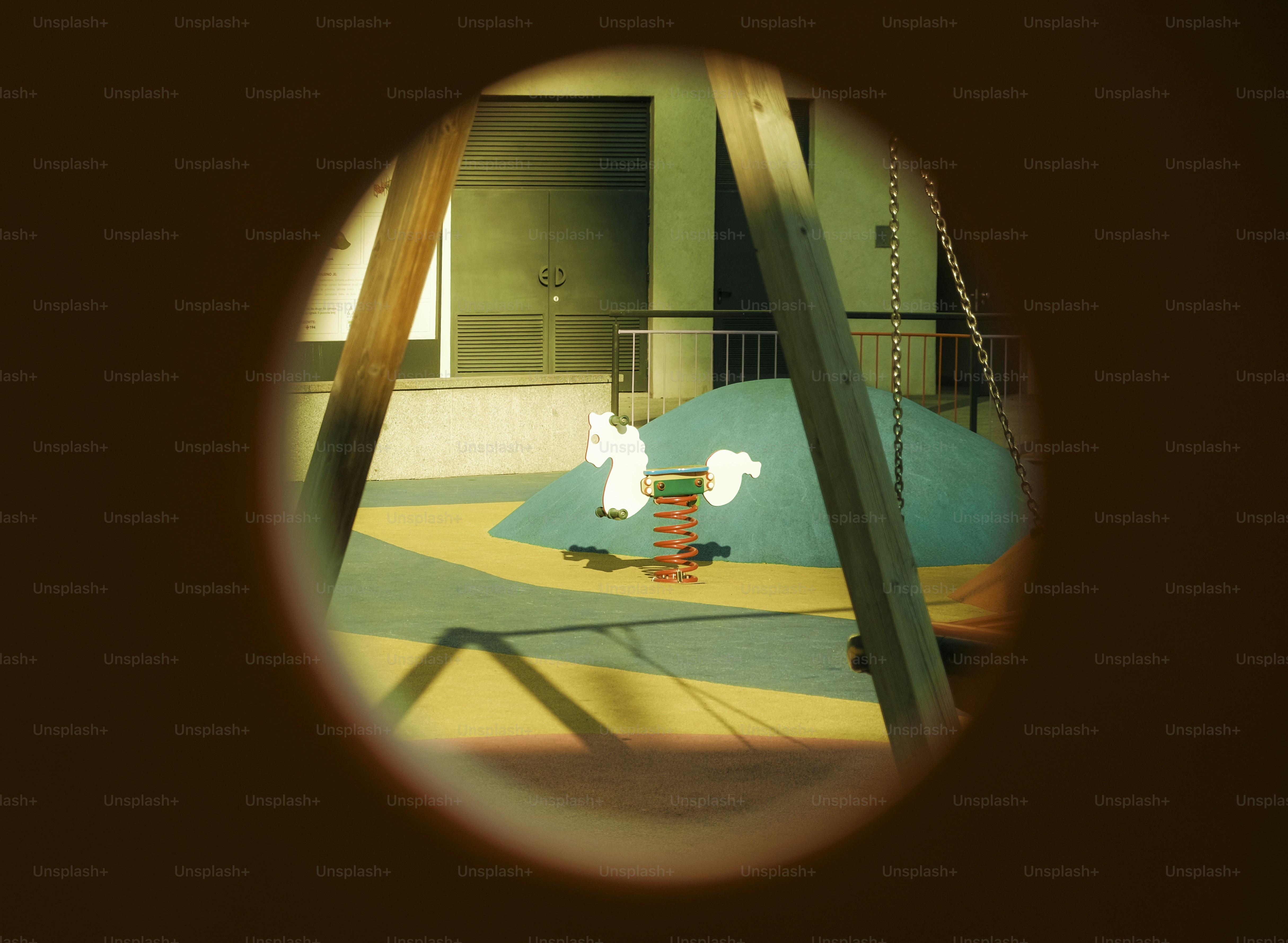 Une aire de jeux est vue à travers un trou.