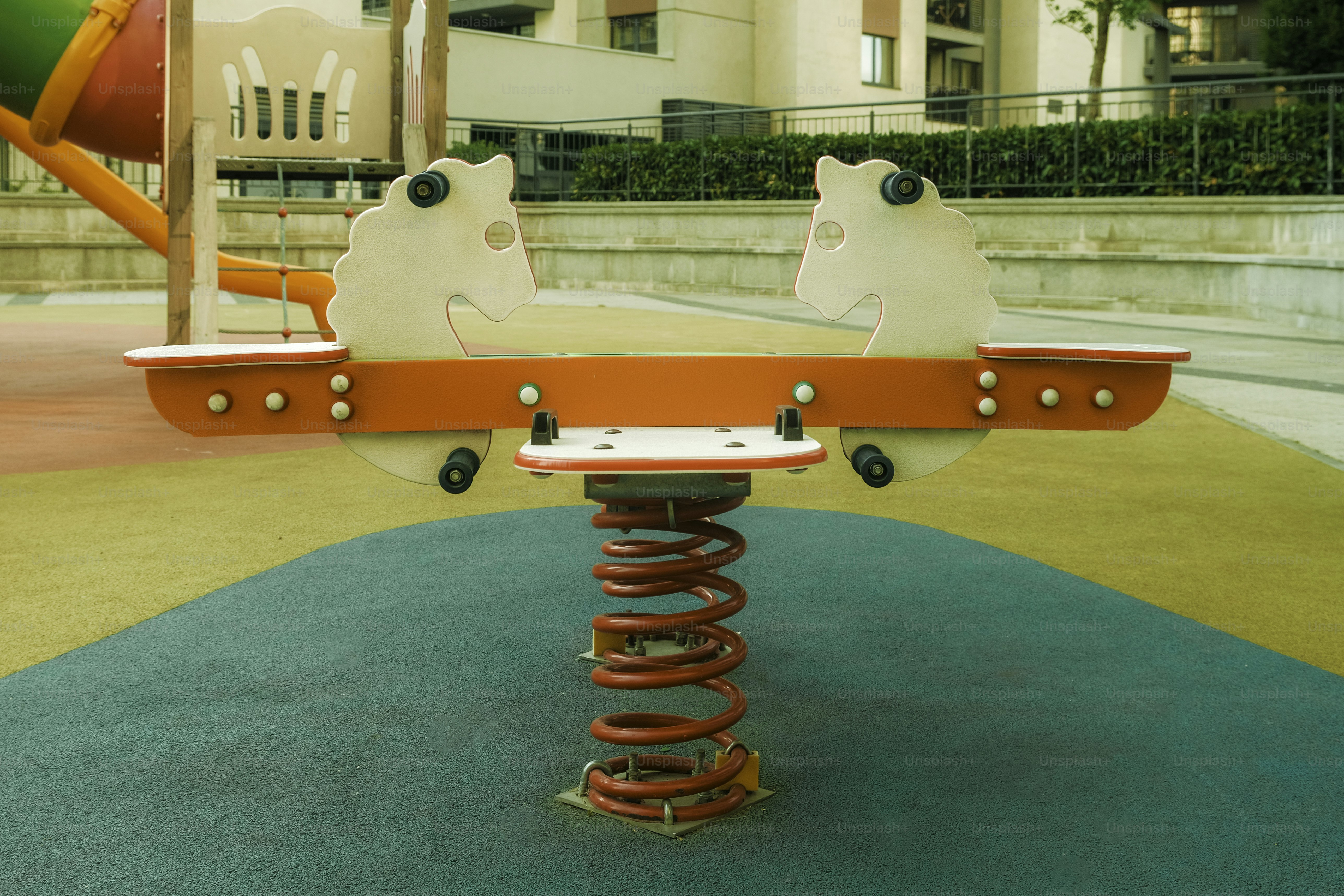 Un cavalier à ressort en forme de cheval est assis sur l’aire de jeux.