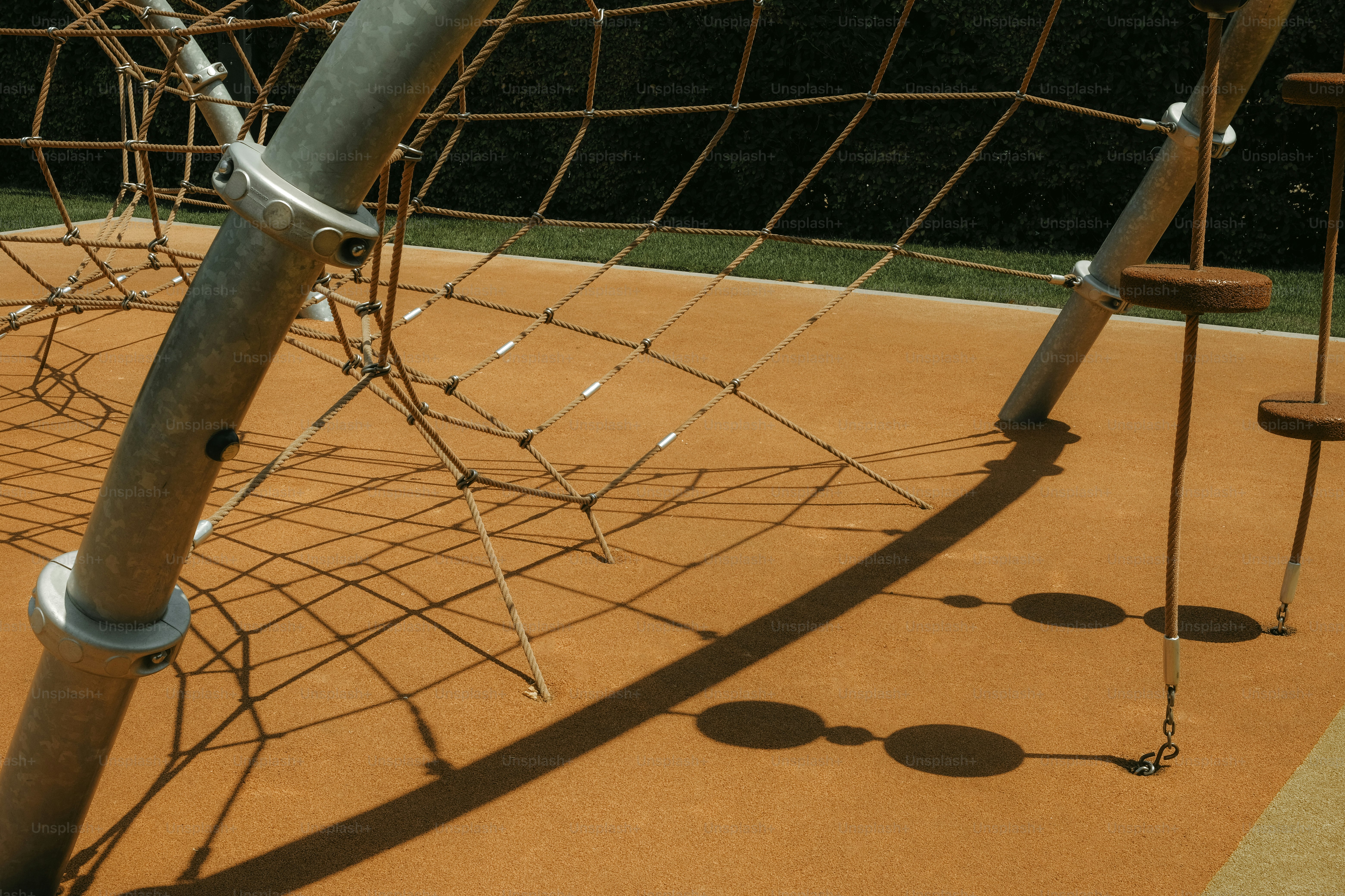A playground structure with a net and posts.