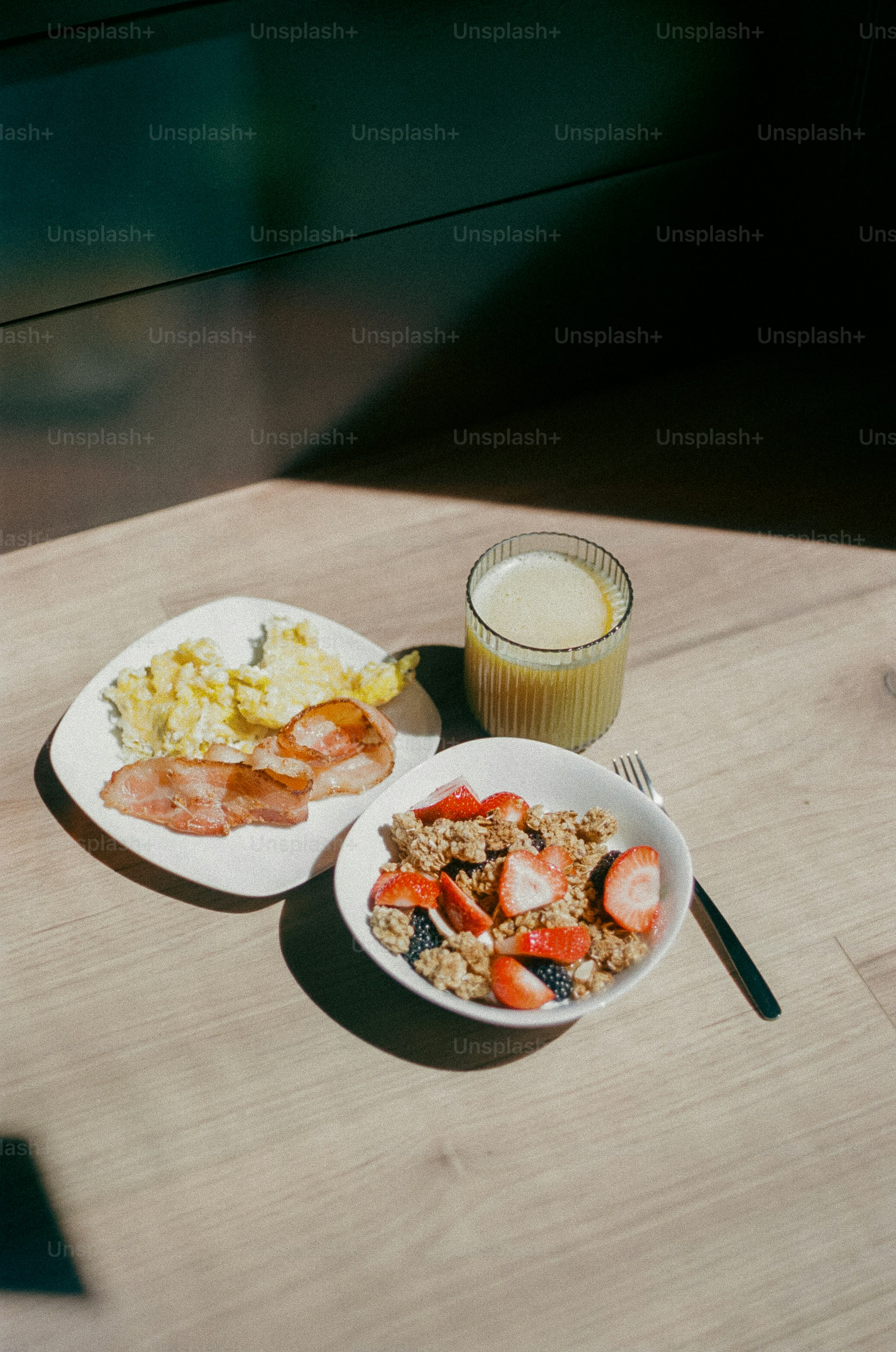 Breakfast includes eggs, bacon, granola, fruit, and juice.