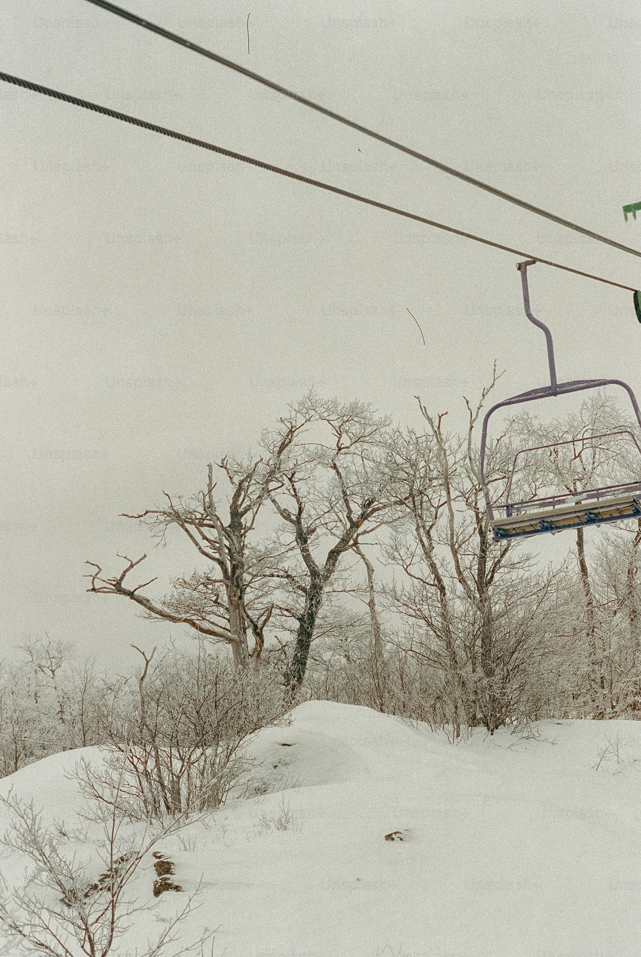 Snowy ski lift with trees and a hill