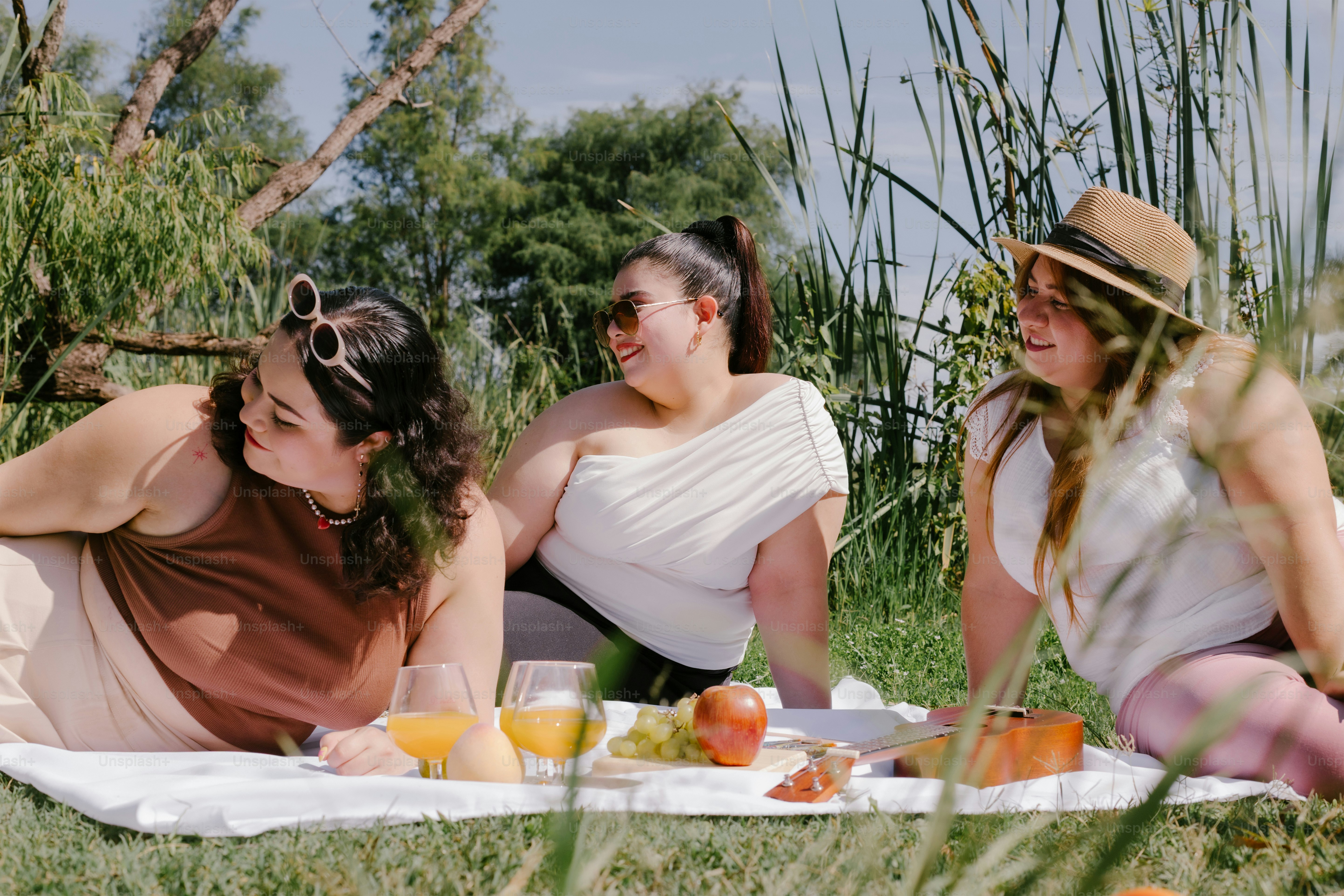 Three friends enjoy a picnic outdoors.