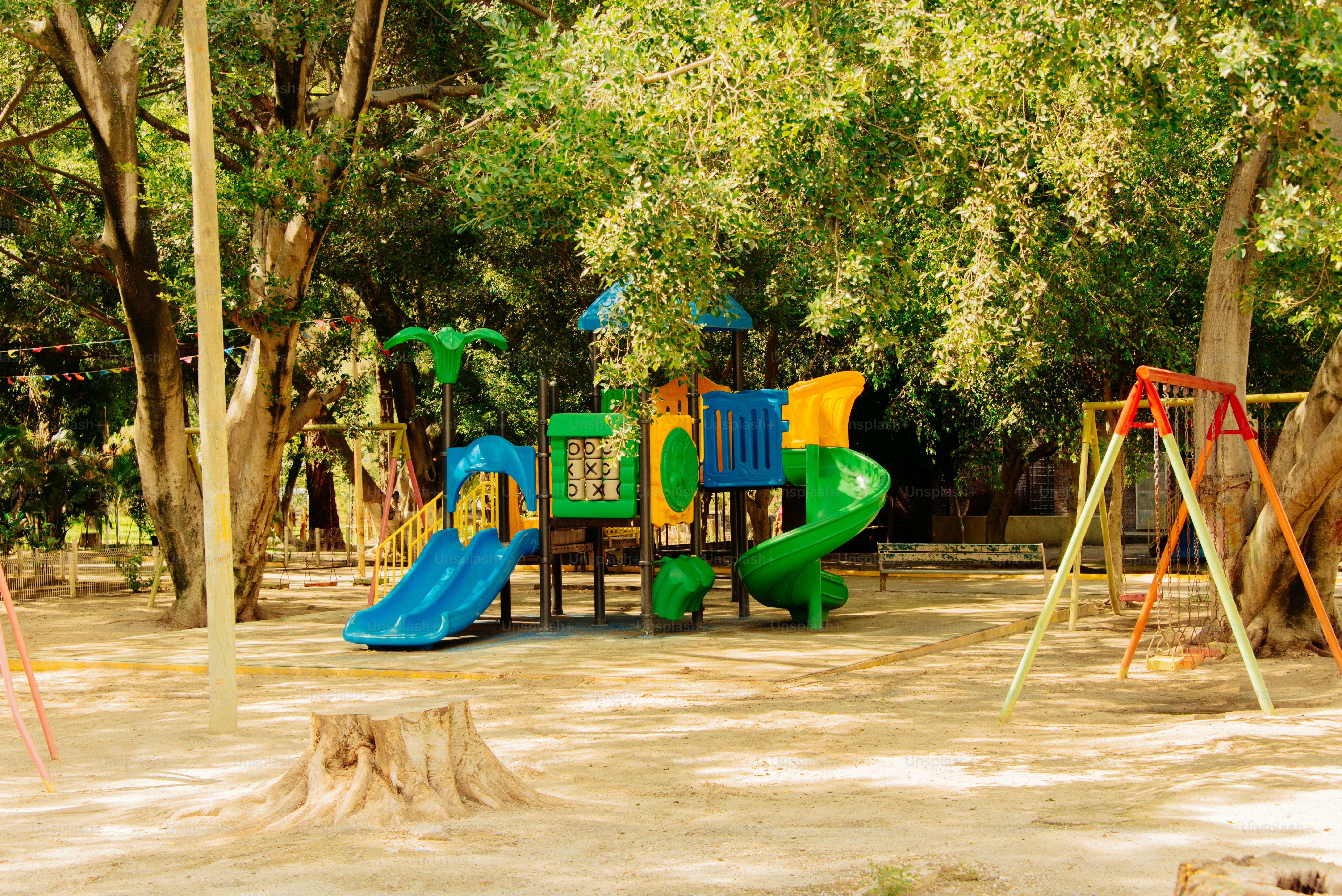 Une aire de jeux est située au milieu d’un parc ombragé.
