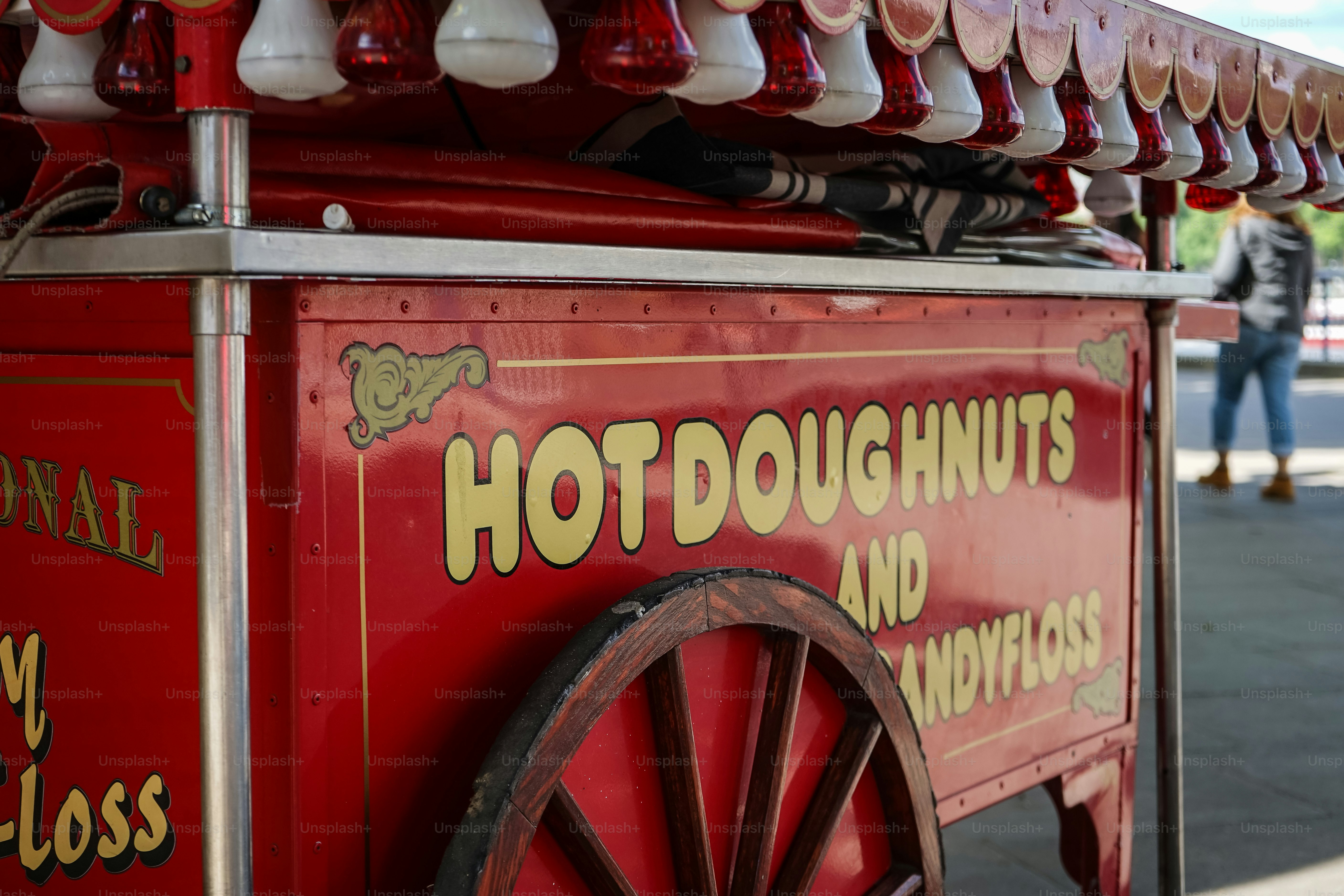 A red hot doughnut cart sells sweet treats.