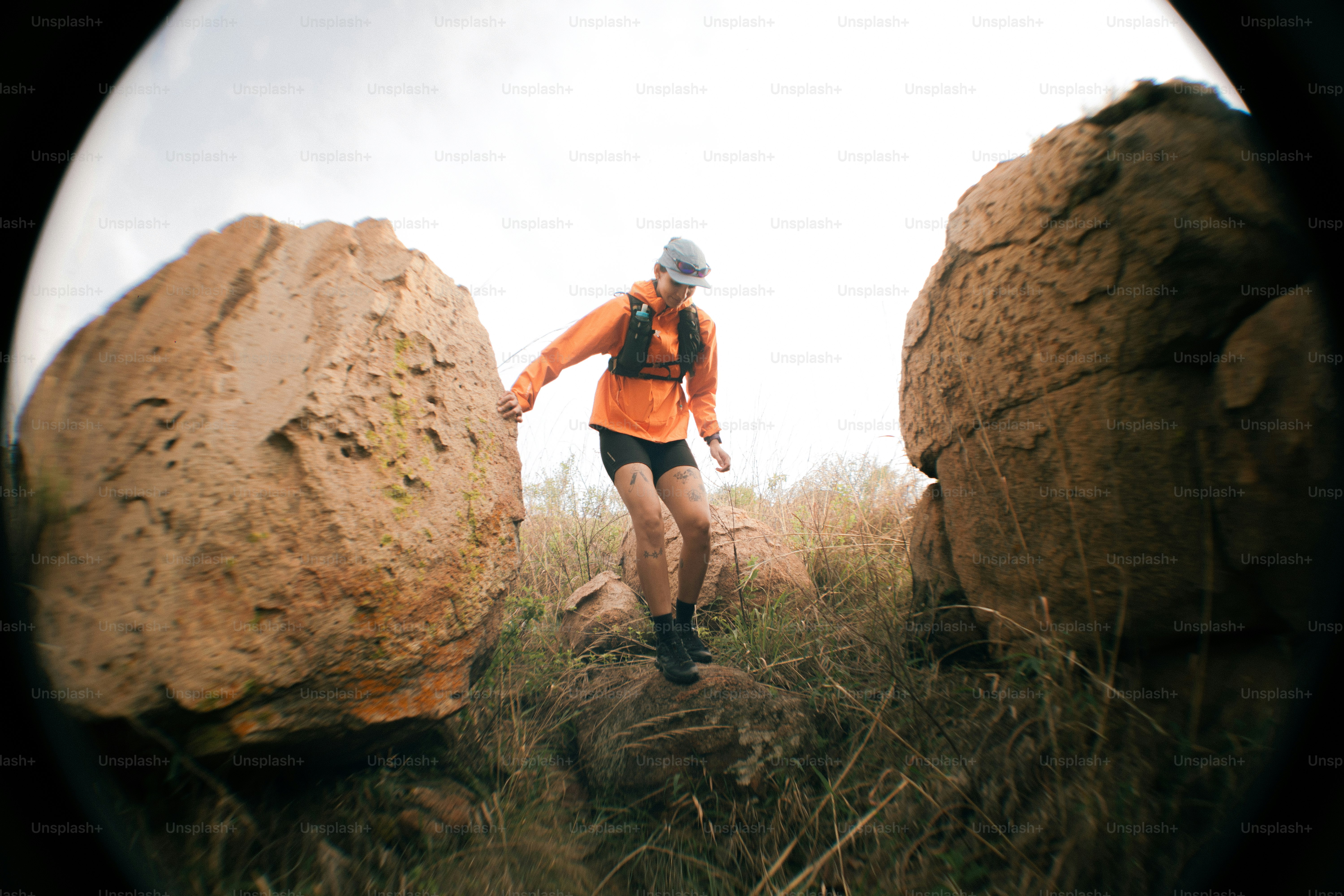 Runner navigates terrain between large boulders.