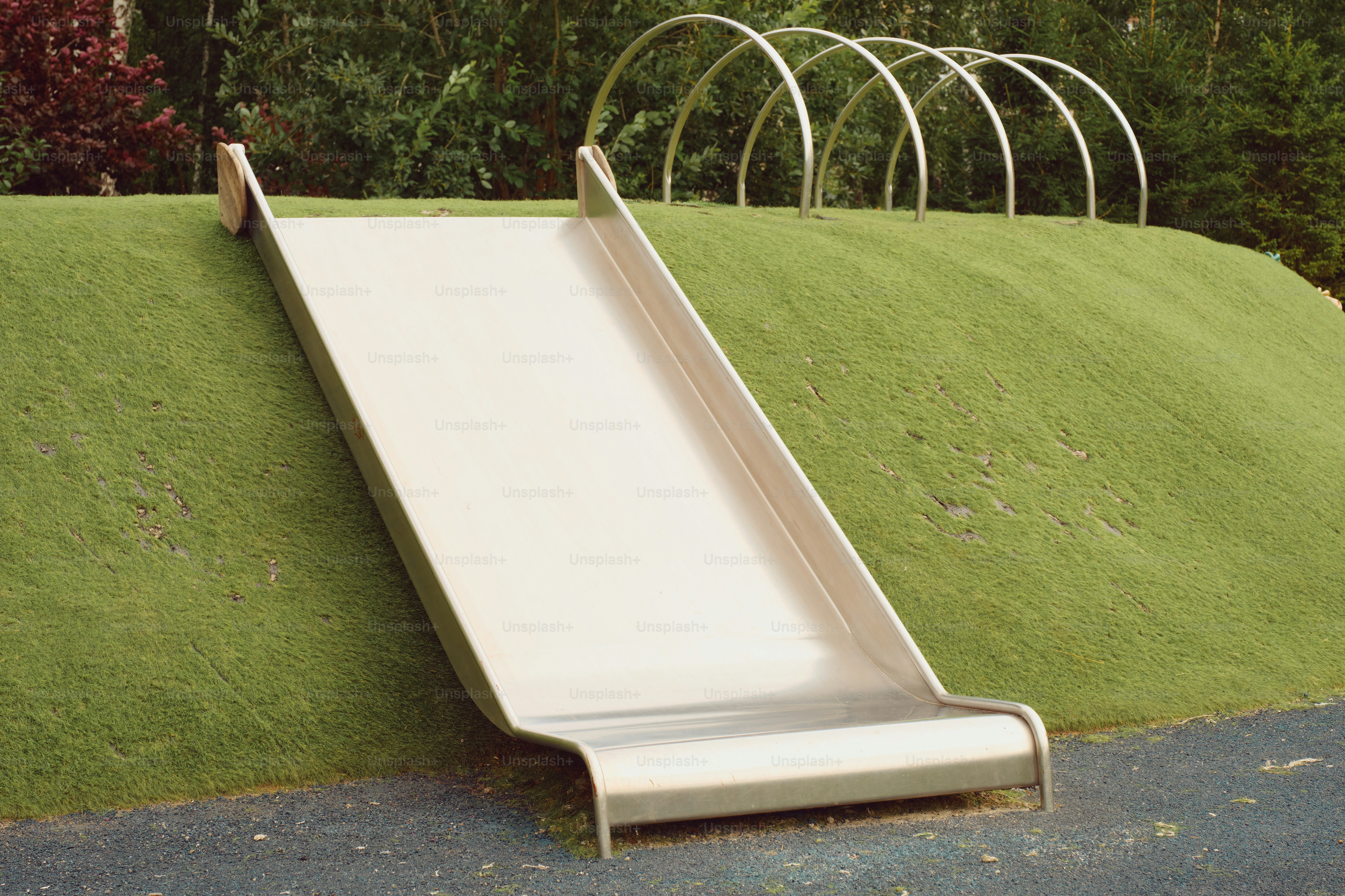 Un toboggan sur une colline herbeuse sur une aire de jeux.