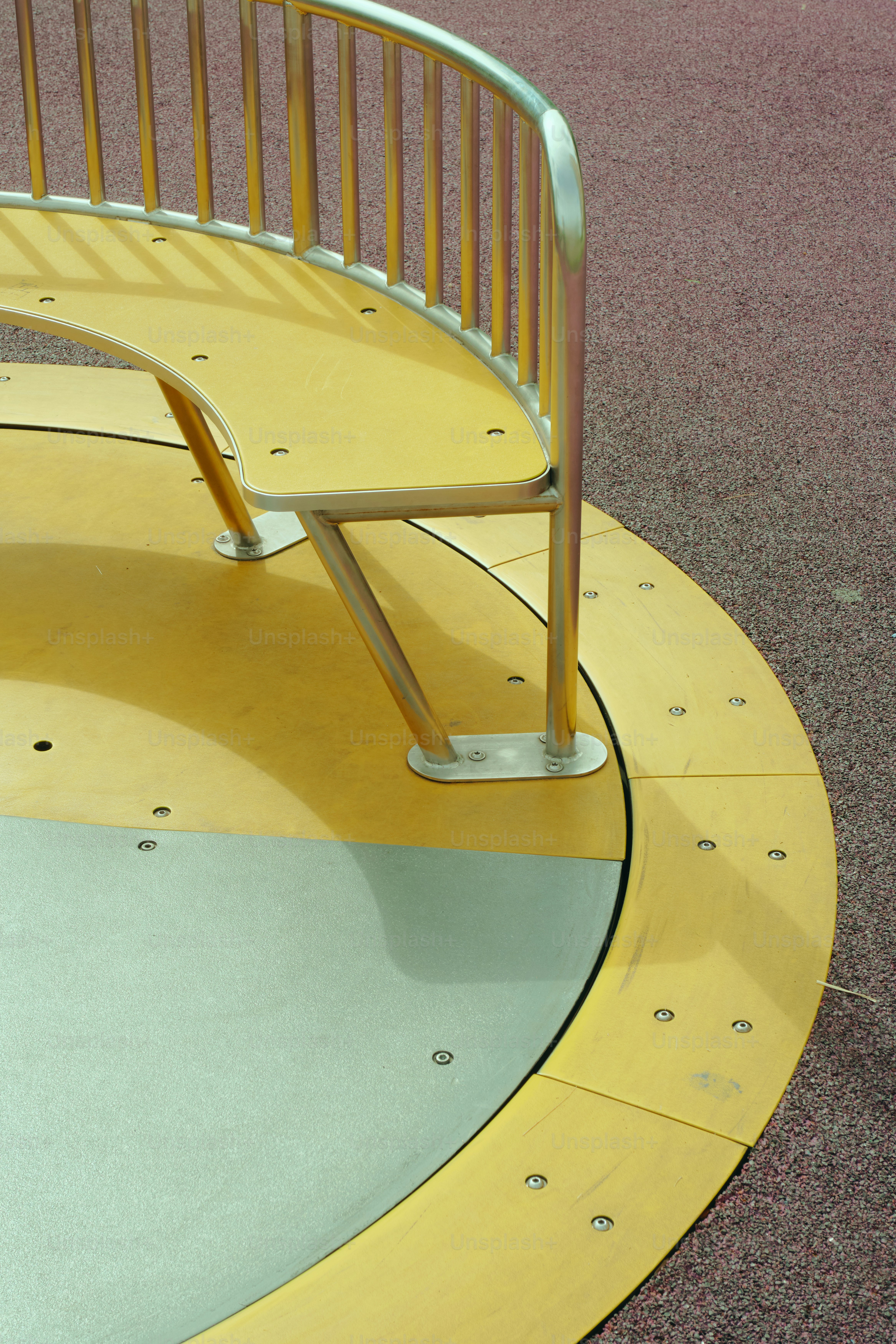 Eine Holzbank mit einem Metallhandlauf.