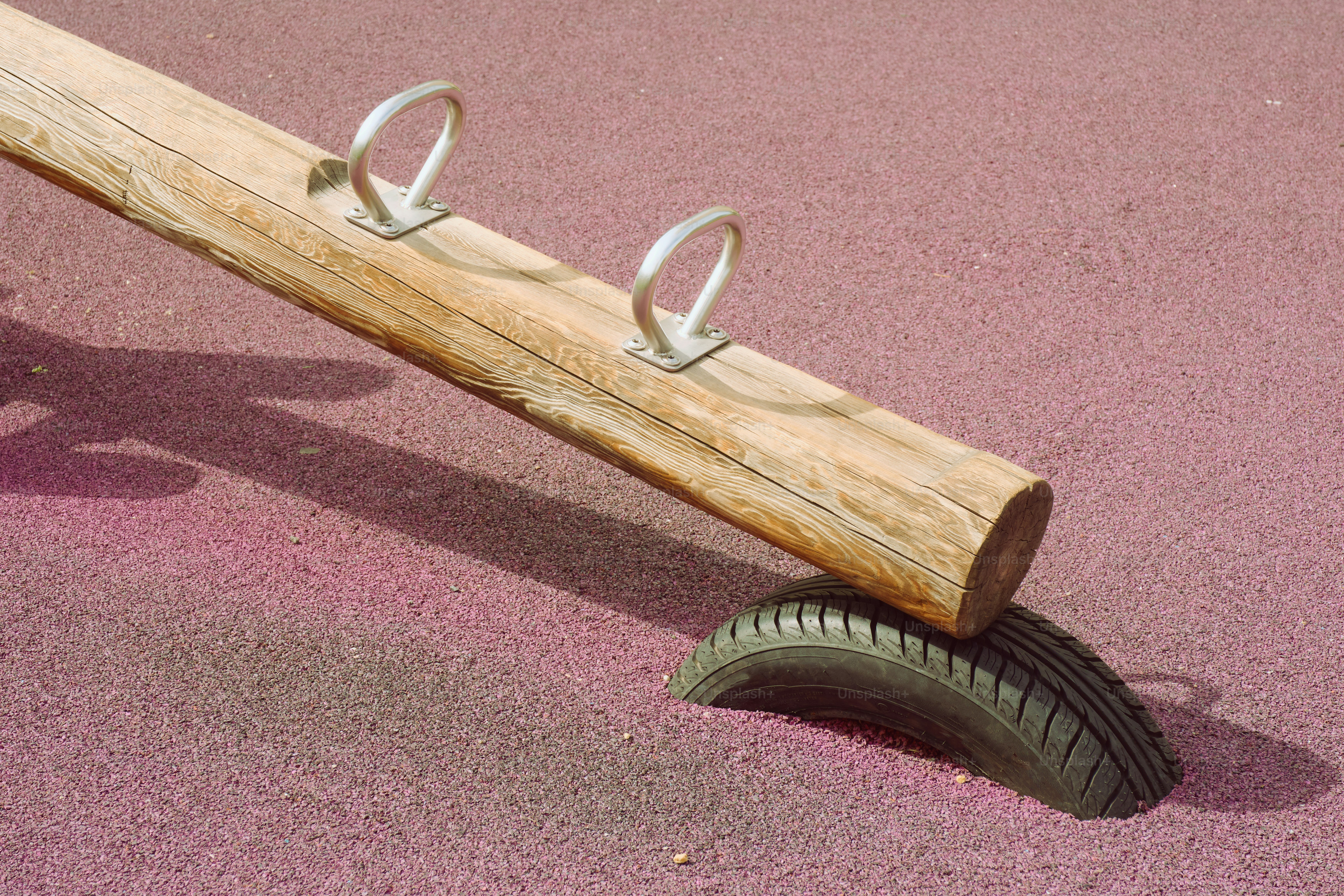 Une balançoire en bois repose sur un vieux pneu.