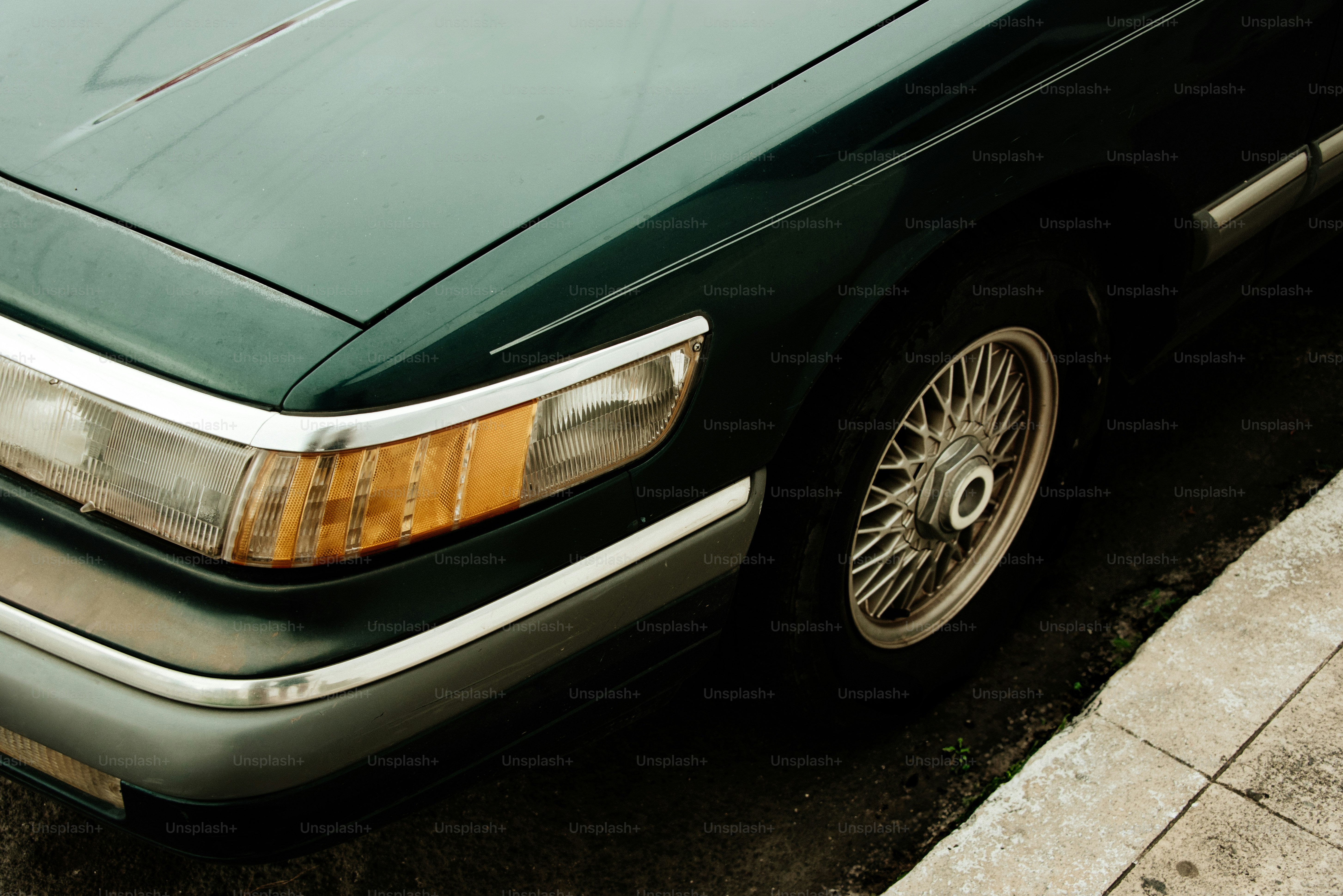 A classic green car's front quarter.