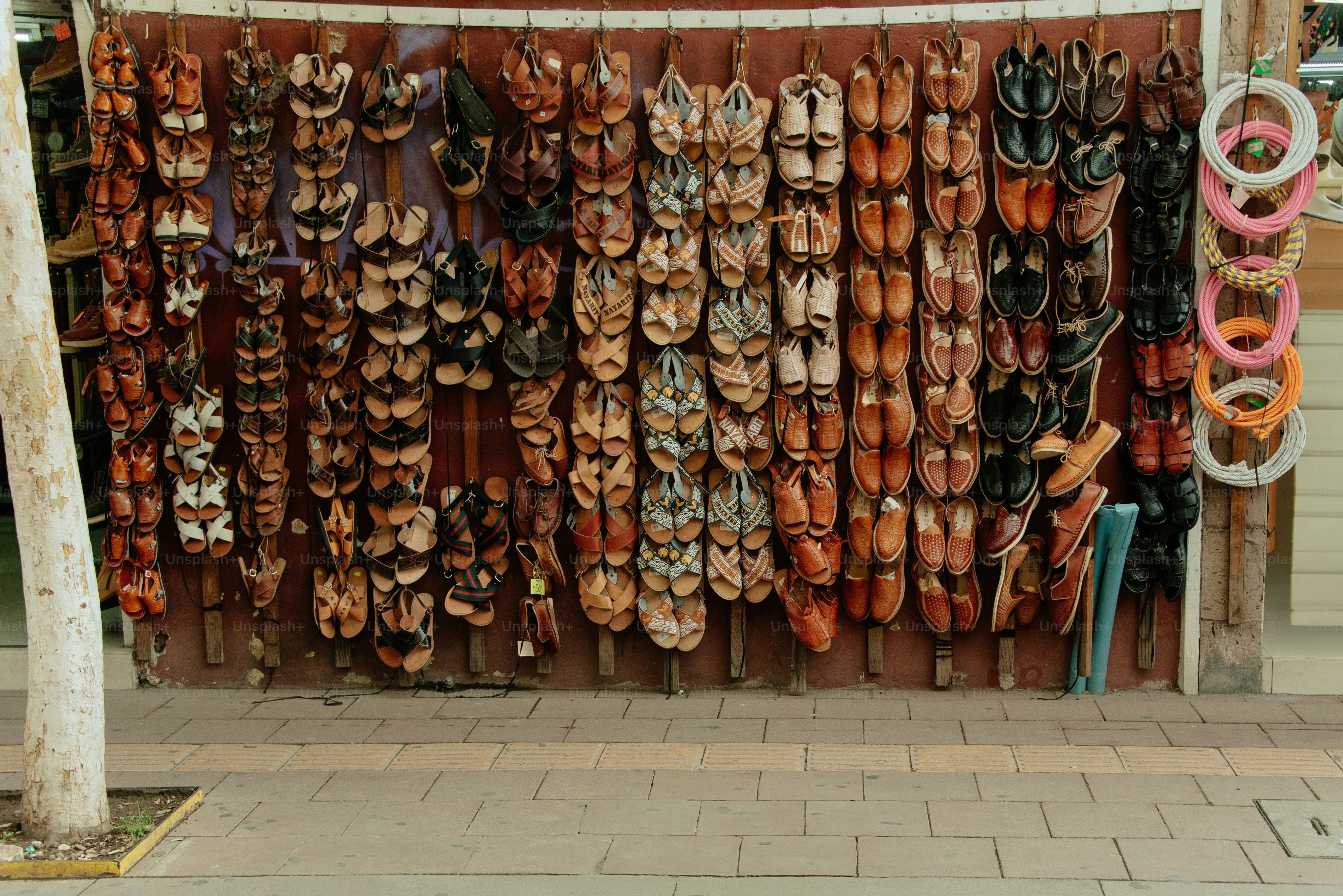 Shoes hang on a wall at a market.