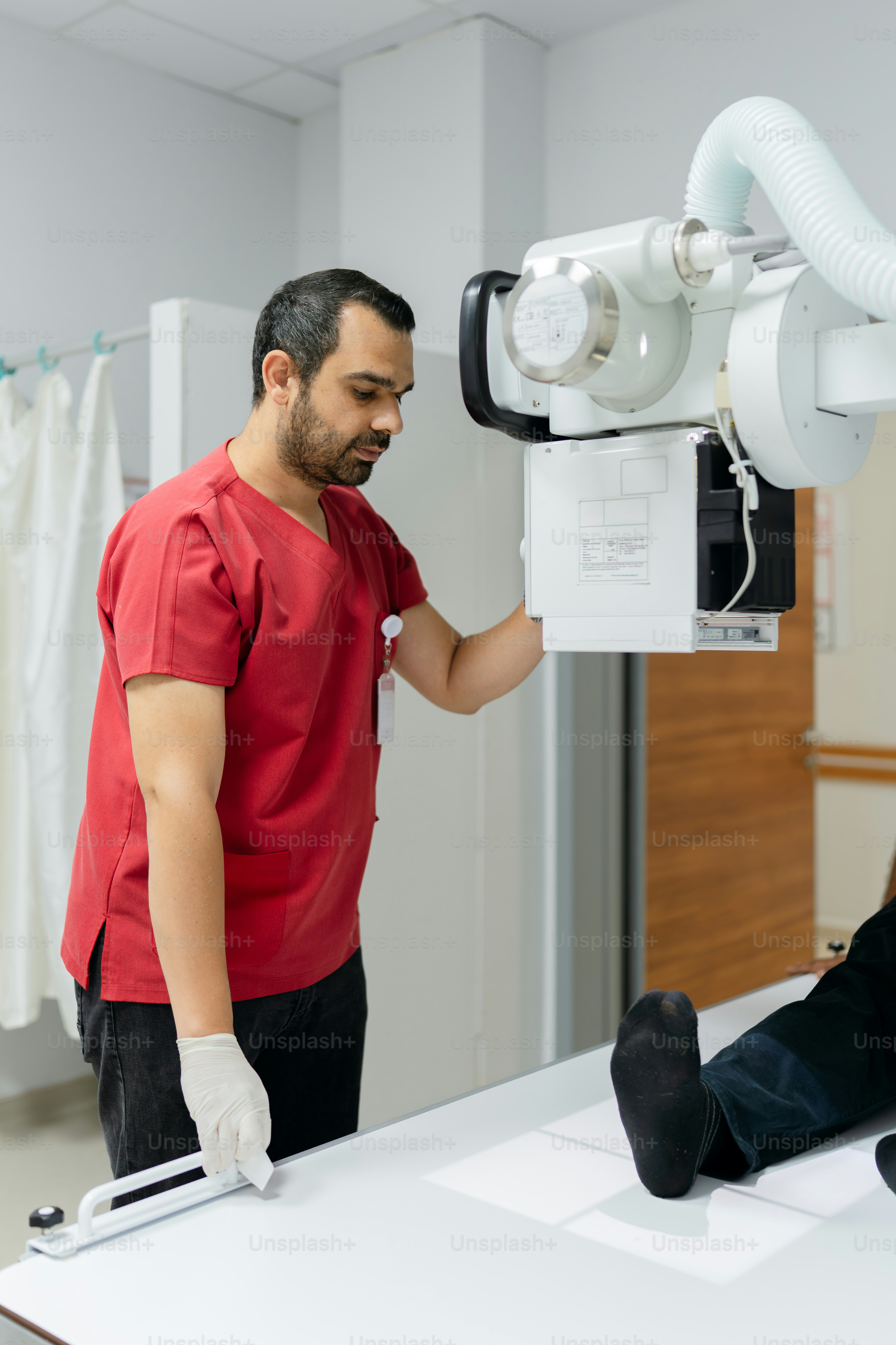 A healthcare worker prepares an x-ray machine. photo – Doctor Image on ...