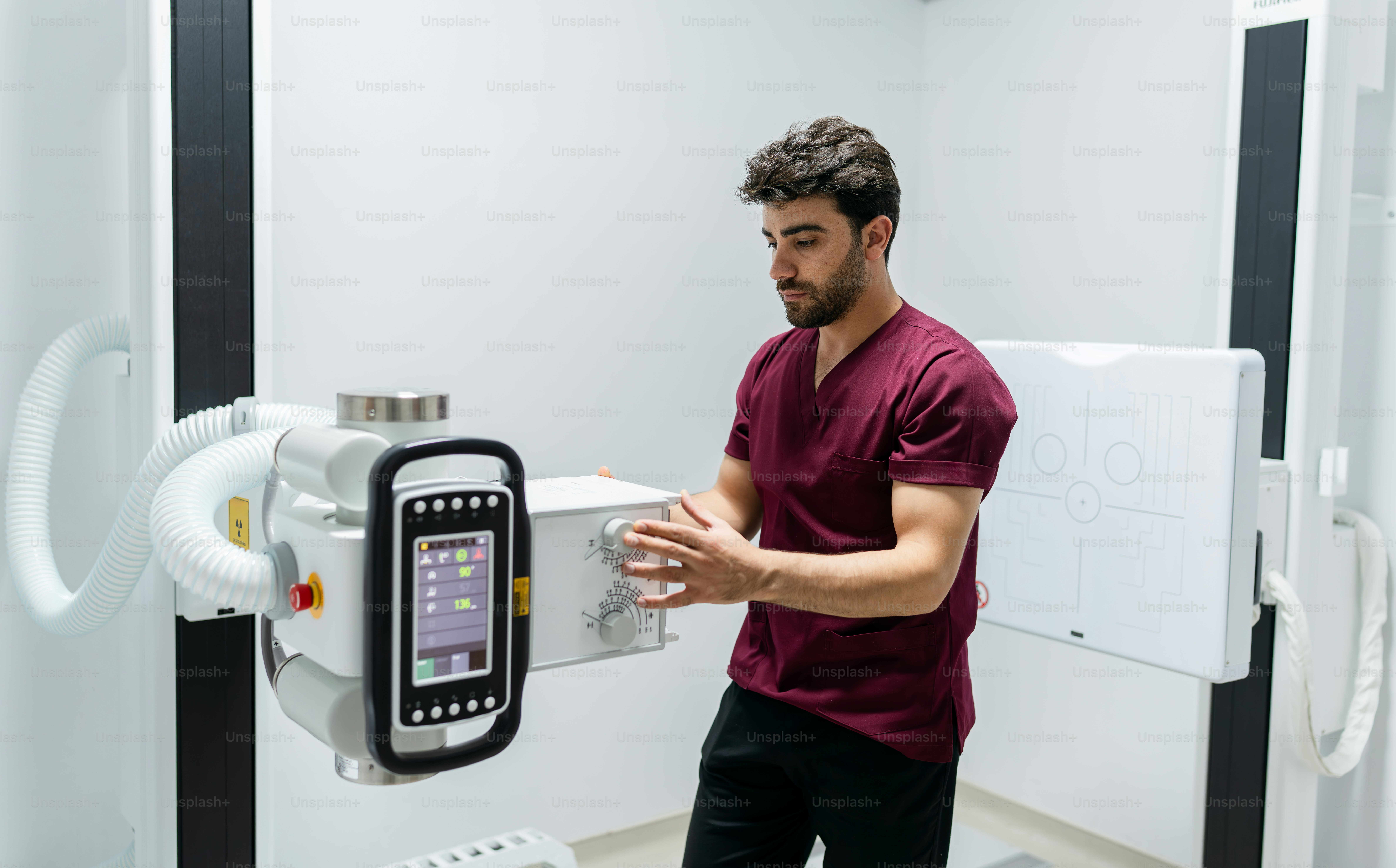 Technician adjusting an x-ray machine in the lab. photo – Doctor Image ...
