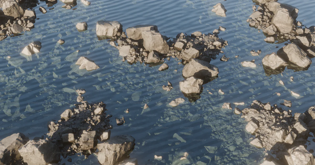 Rocks float in clear, shallow water. photo – Render Image on Unsplash