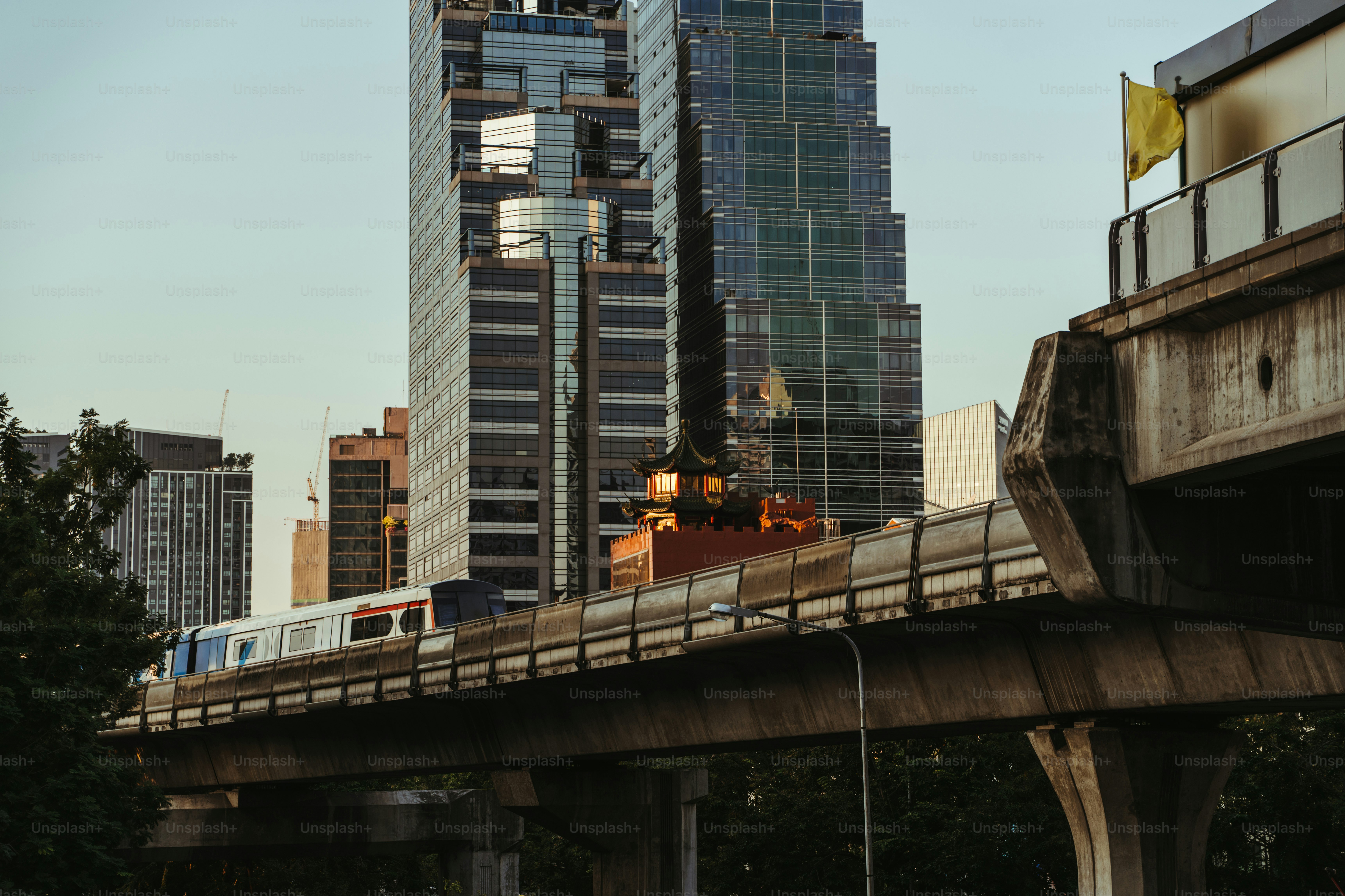Elevated train passes by skyscrapers in a city.