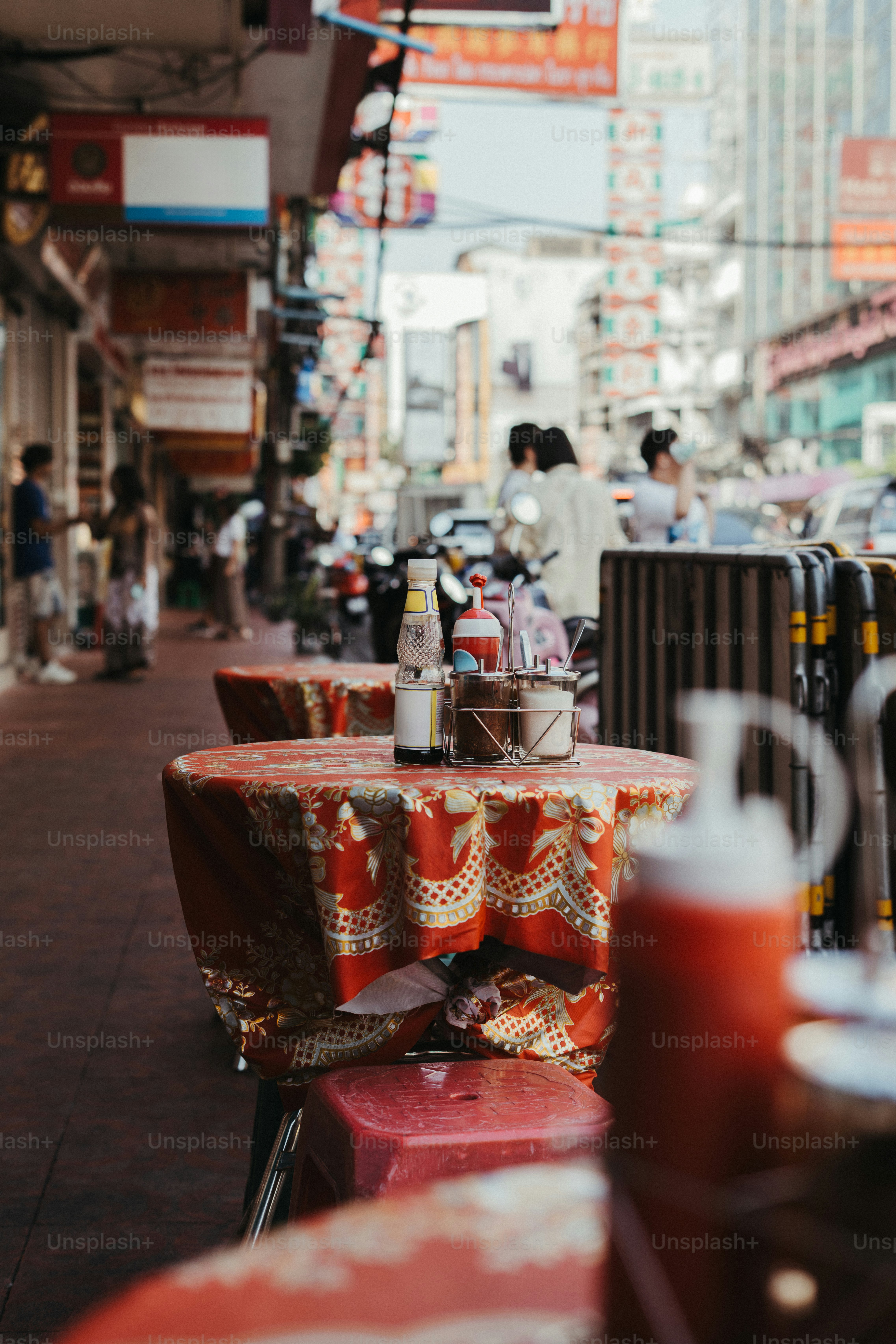 Outdoor dining table with condiments on a busy street