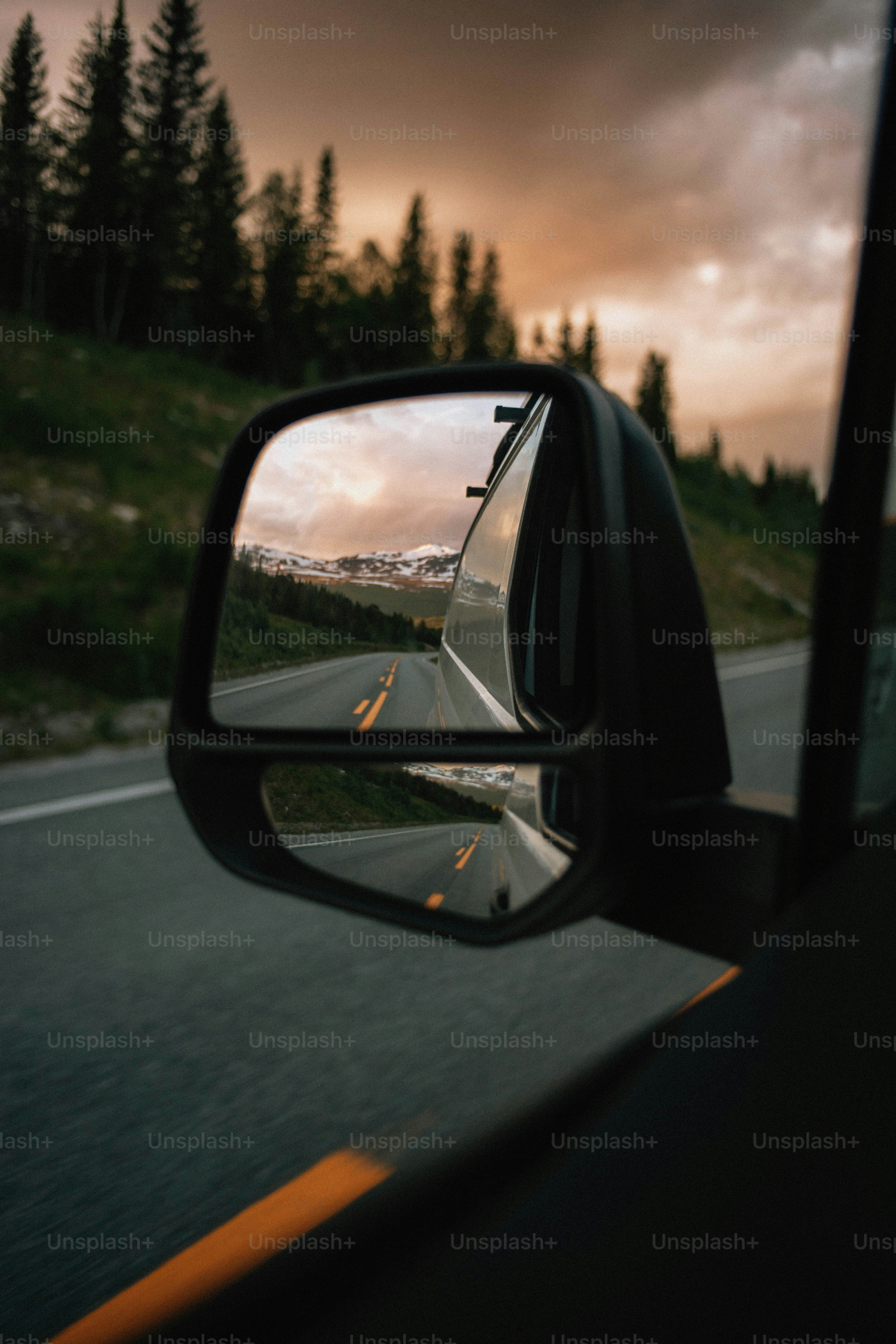 El espejo lateral refleja una carretera de montaña.