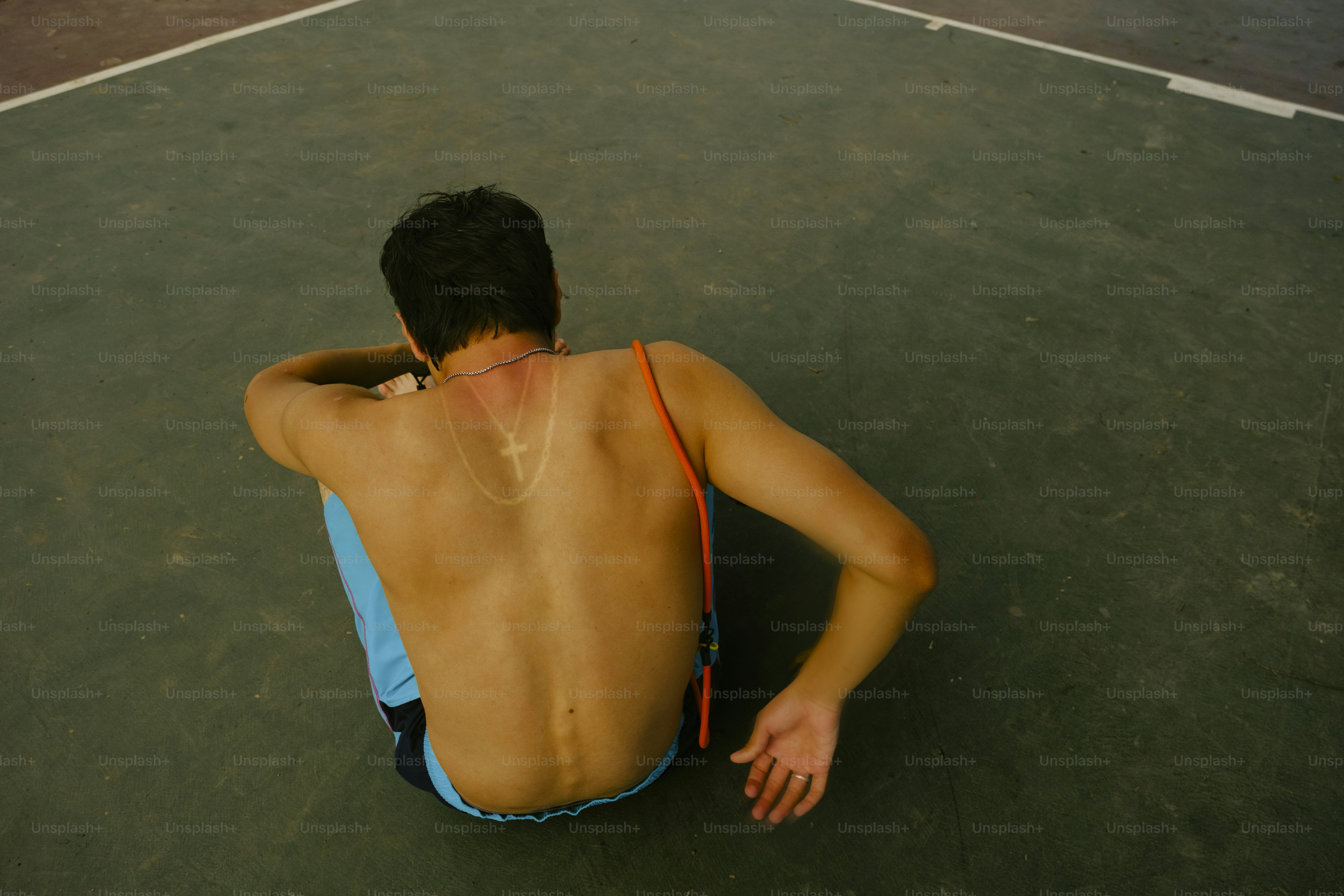 Un homme est assis, face à face, sur le sol.