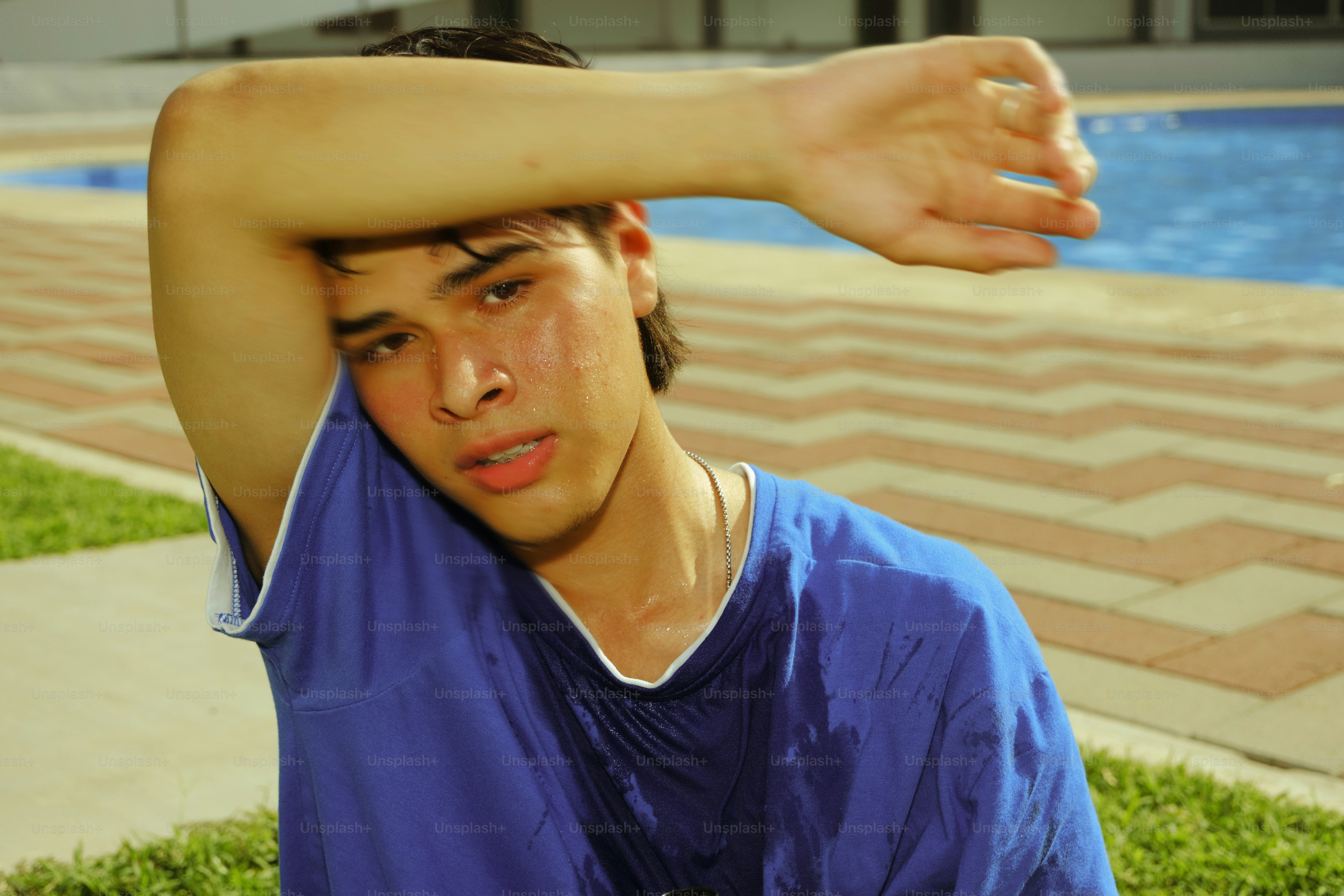 A tired man wipes sweat from his forehead.