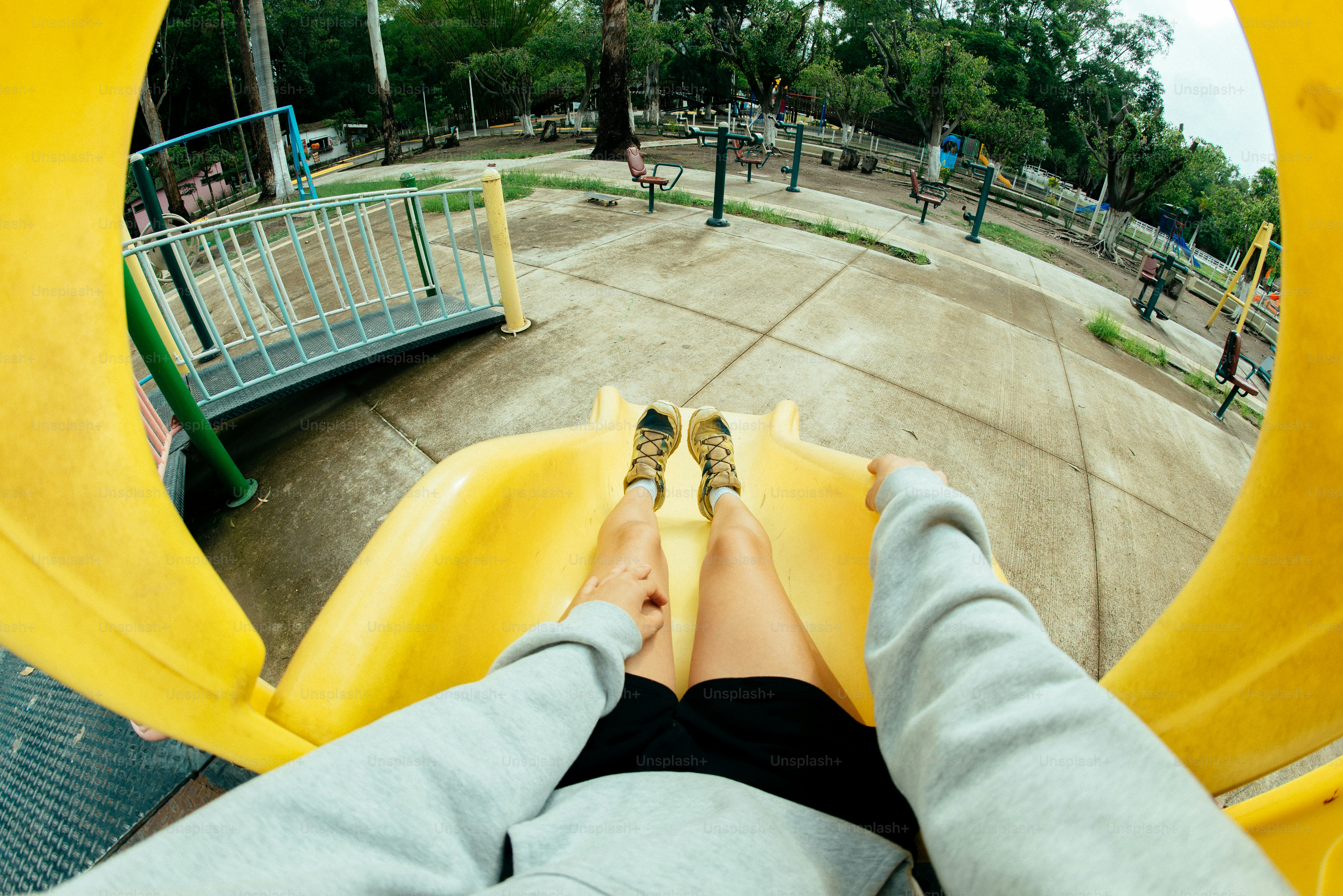 Sliding down a yellow slide at the playground.
