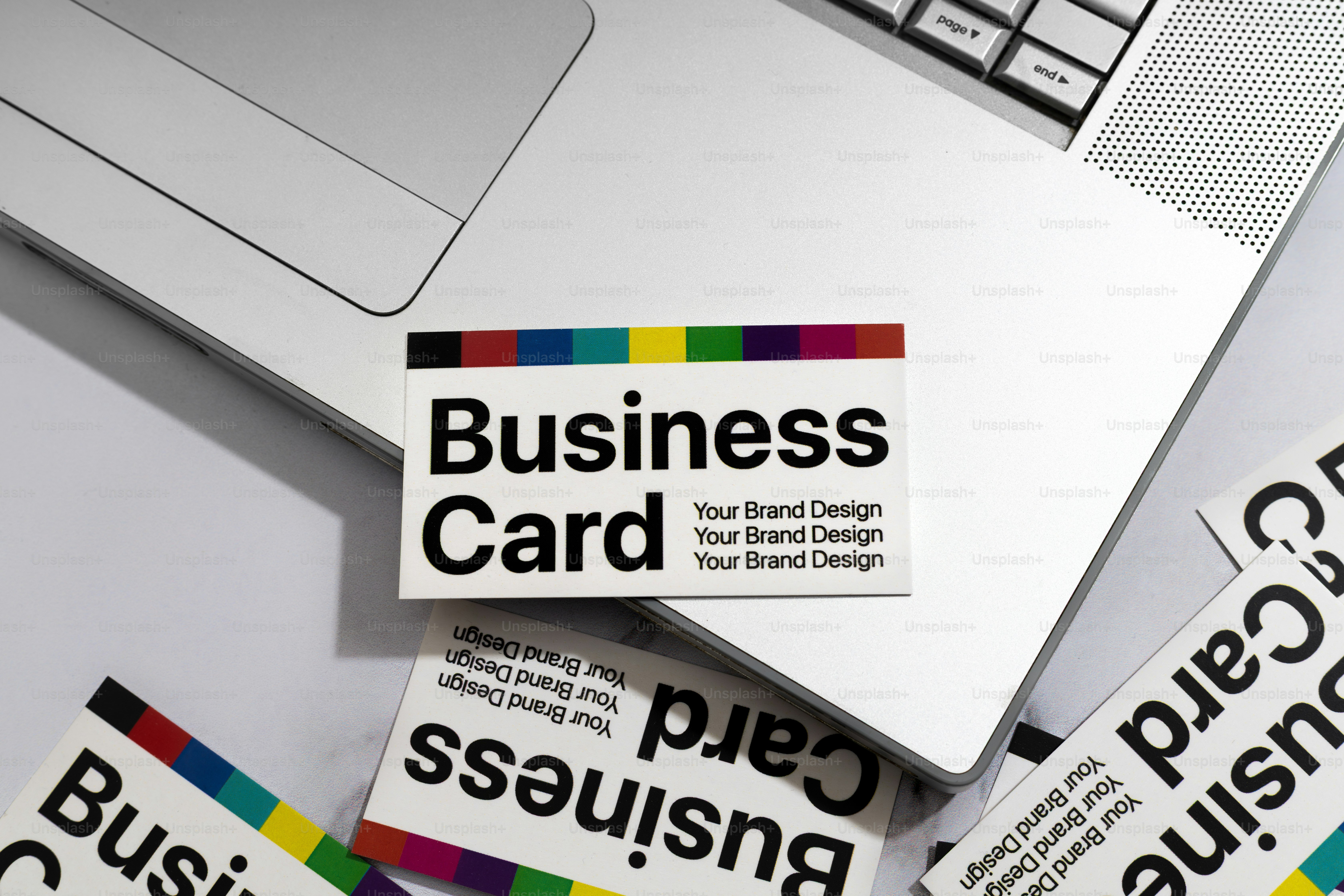 Business cards are resting on a laptop.