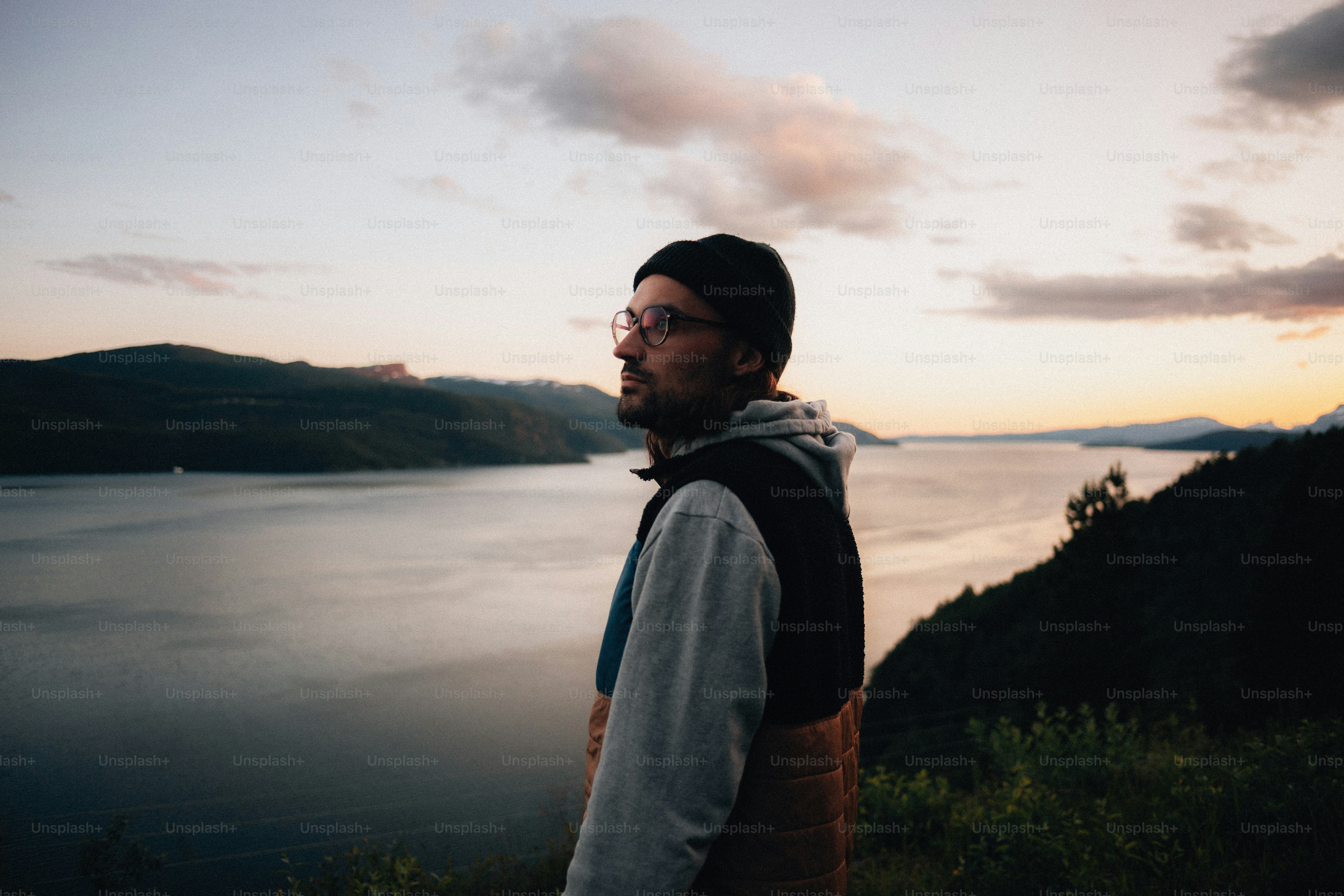 Der Mensch schaut auf den Sonnenuntergang über einem riesigen See.