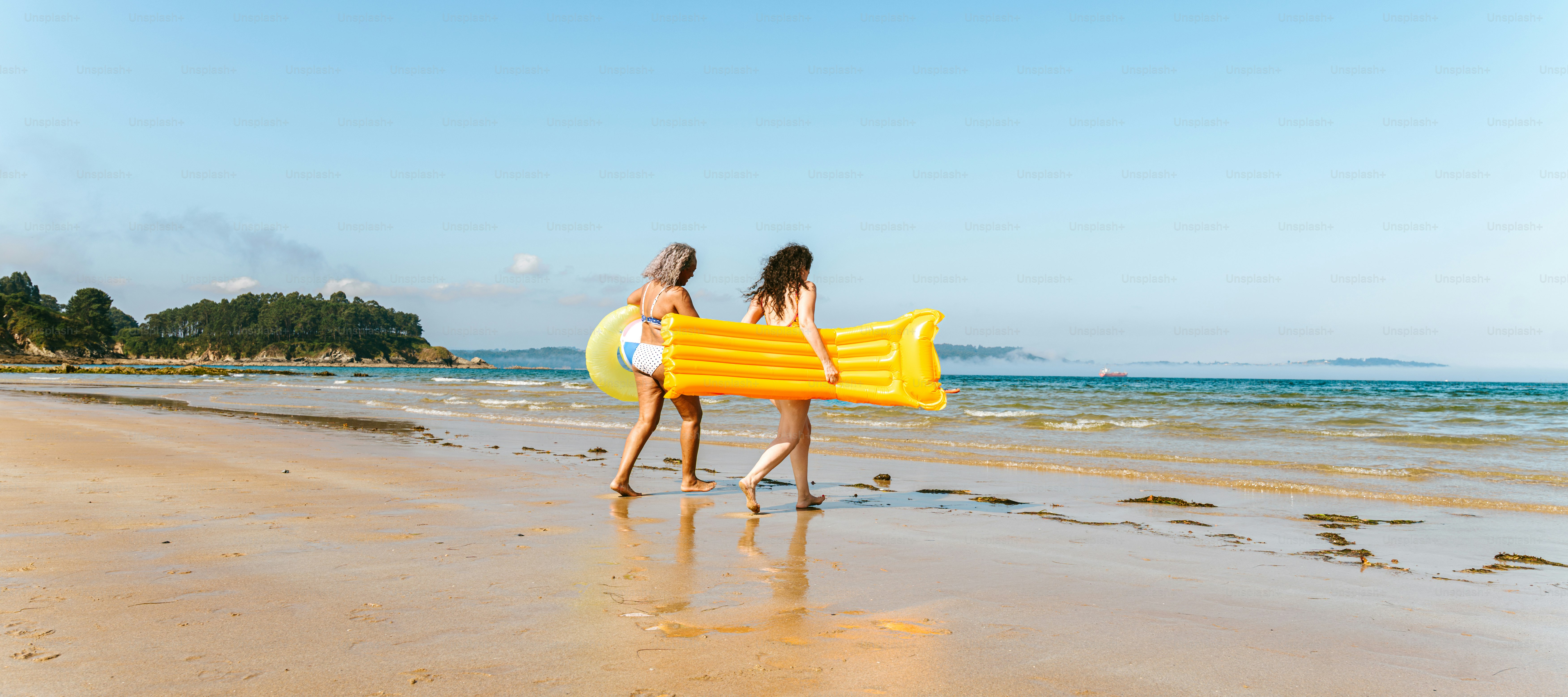 Two friends walk along the beach.