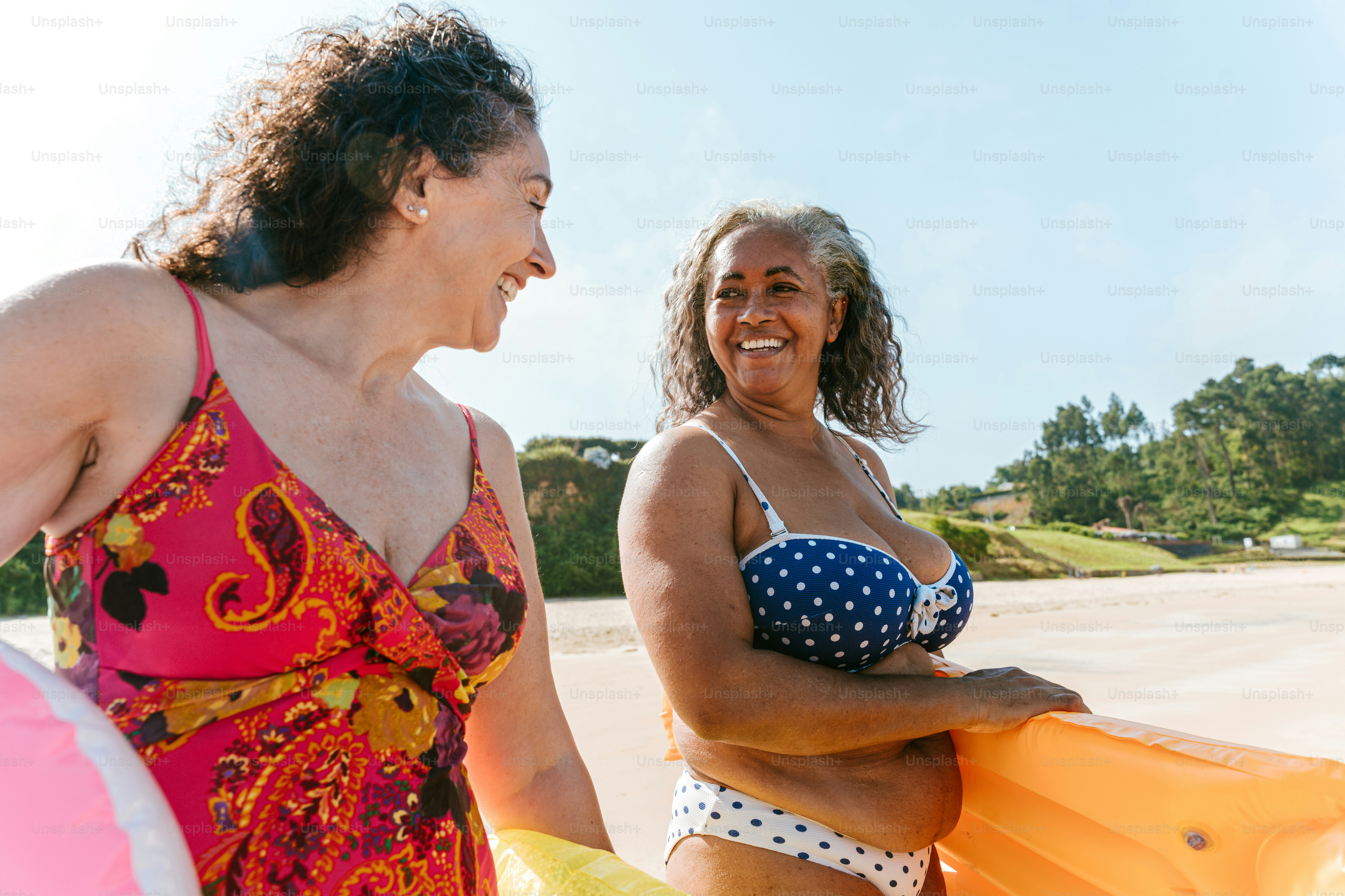 Dua wanita yang lebih tua menikmati hari pantai bersama.