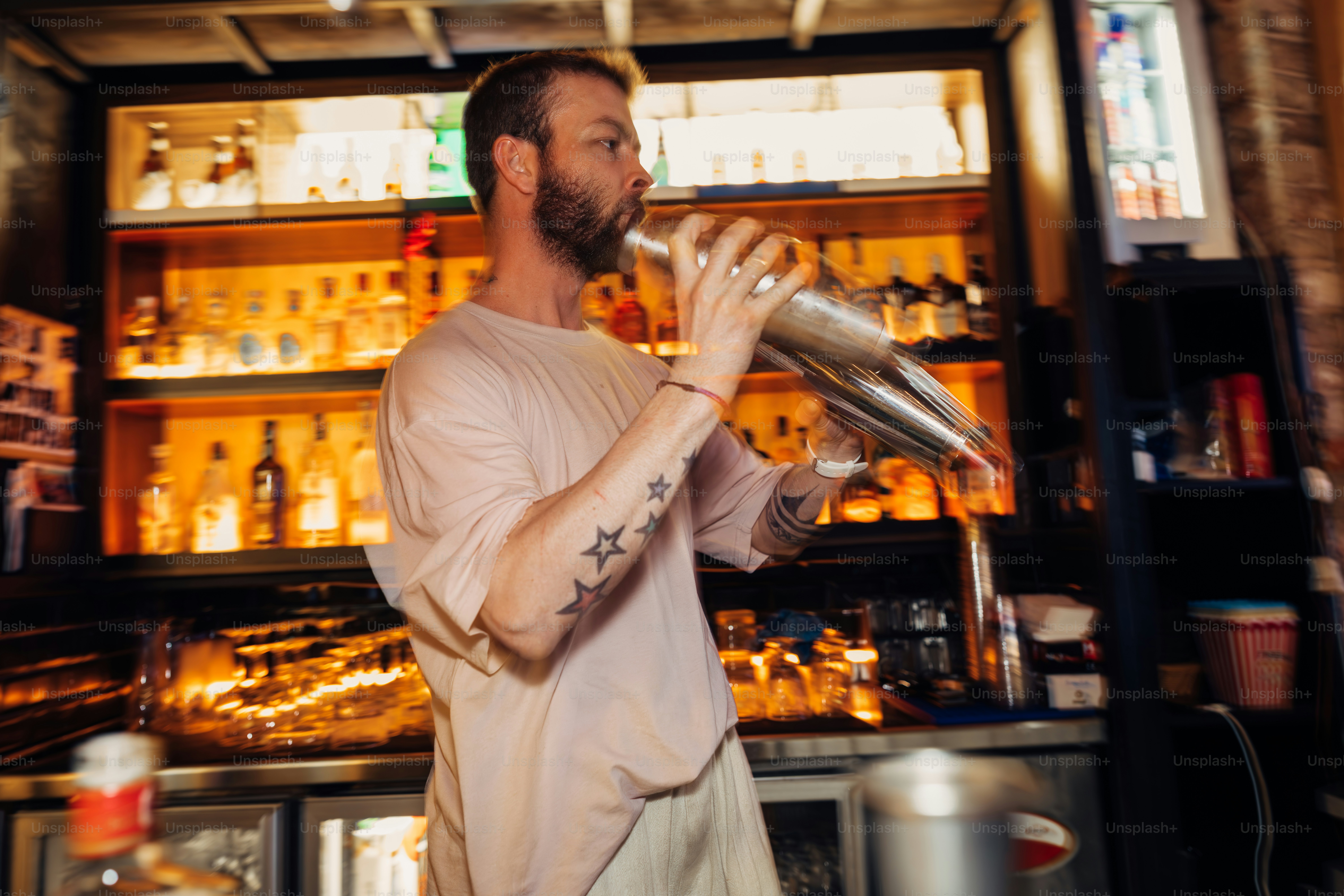 Bartender shakes a cocktail shaker behind the bar.