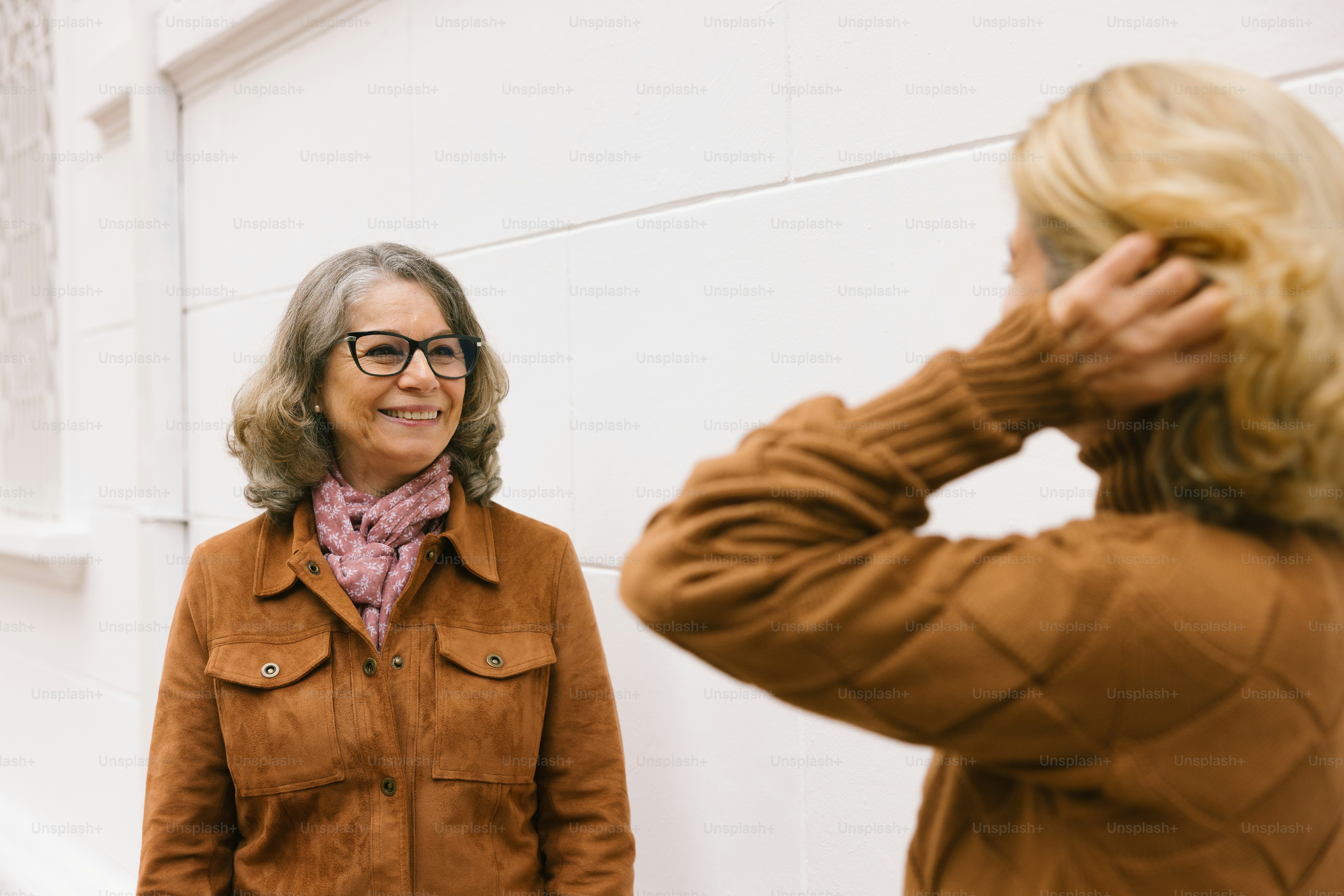 Two women stand, one facing the other.