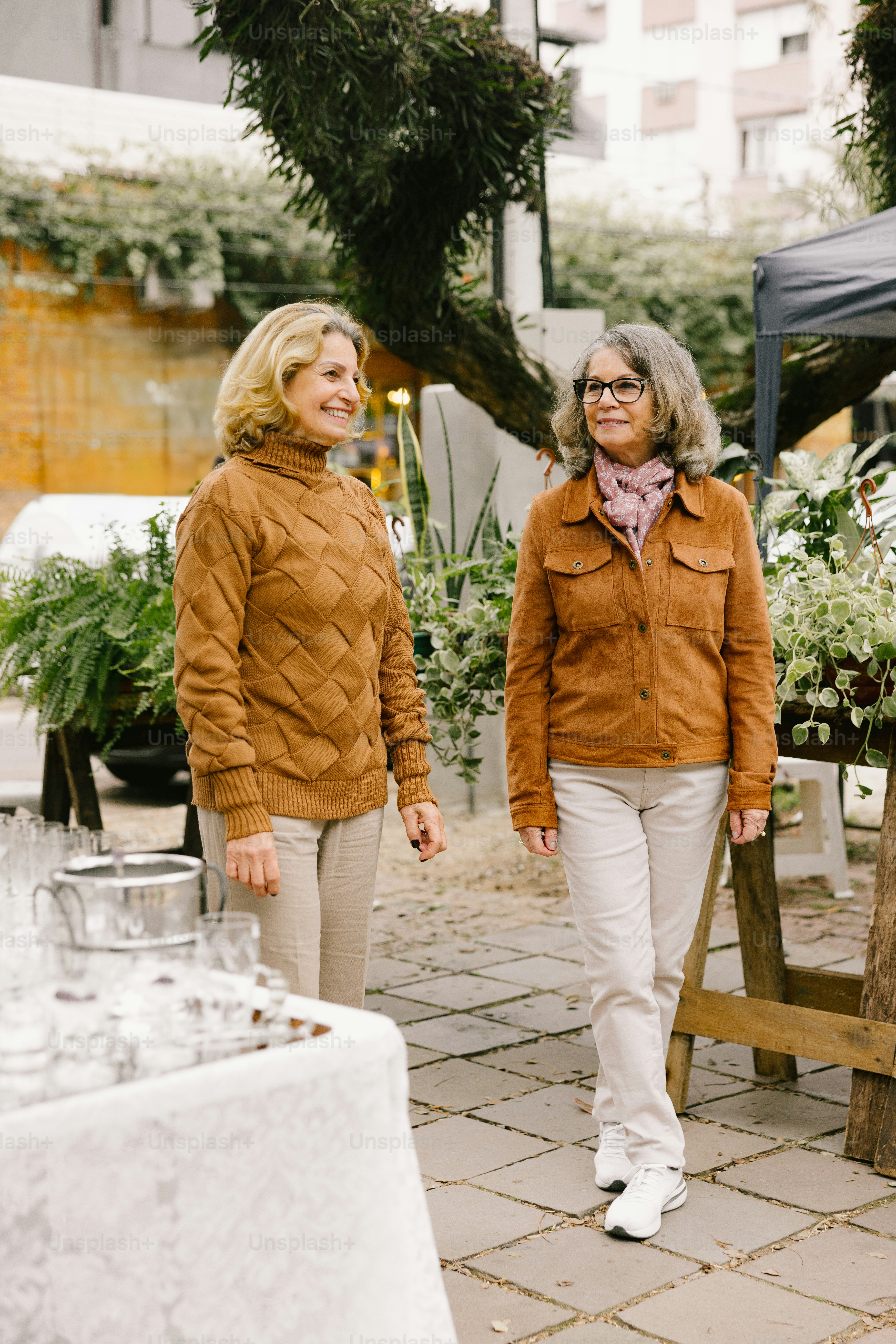 Two women stand together outside.
