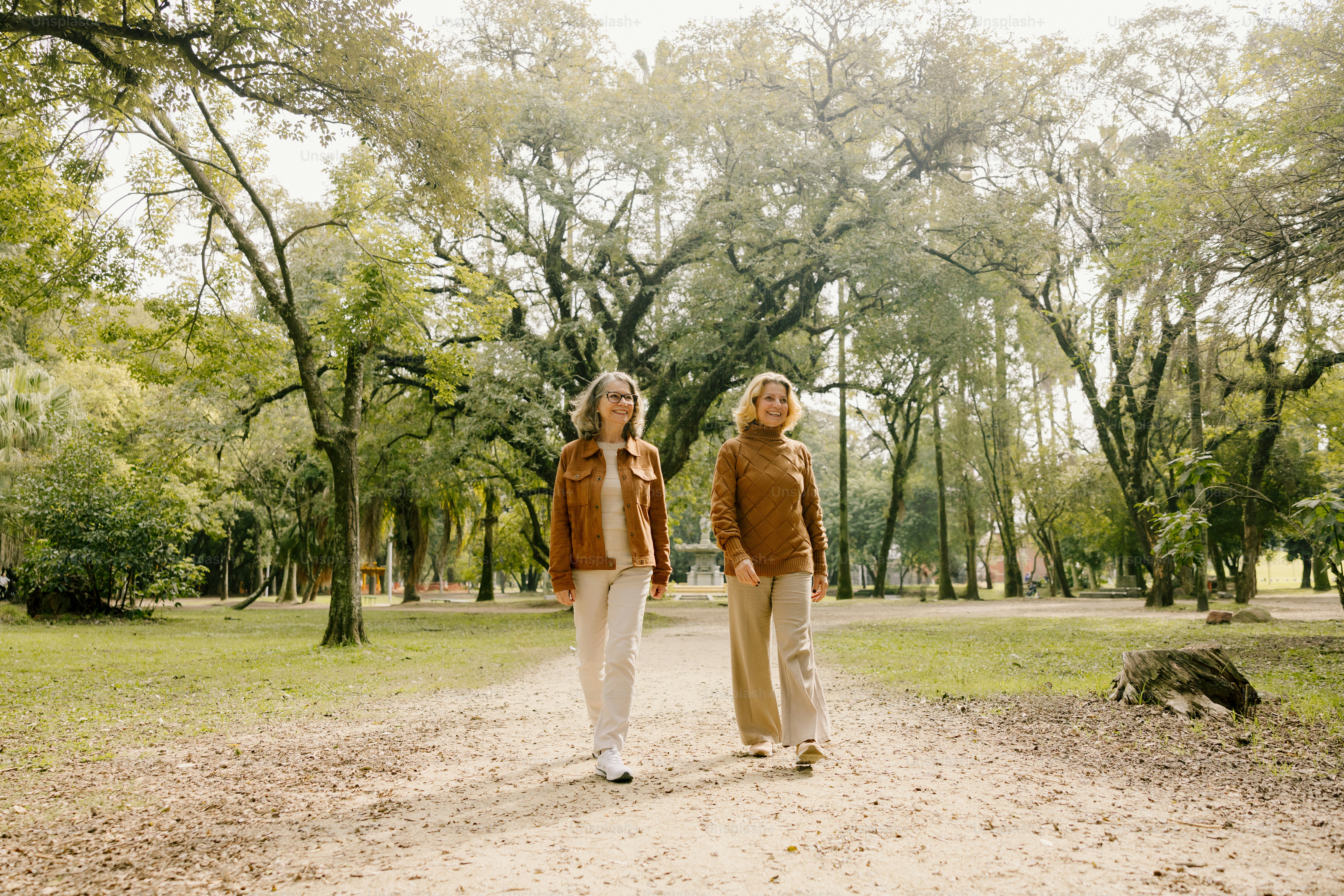 Two women walk together on a park path.