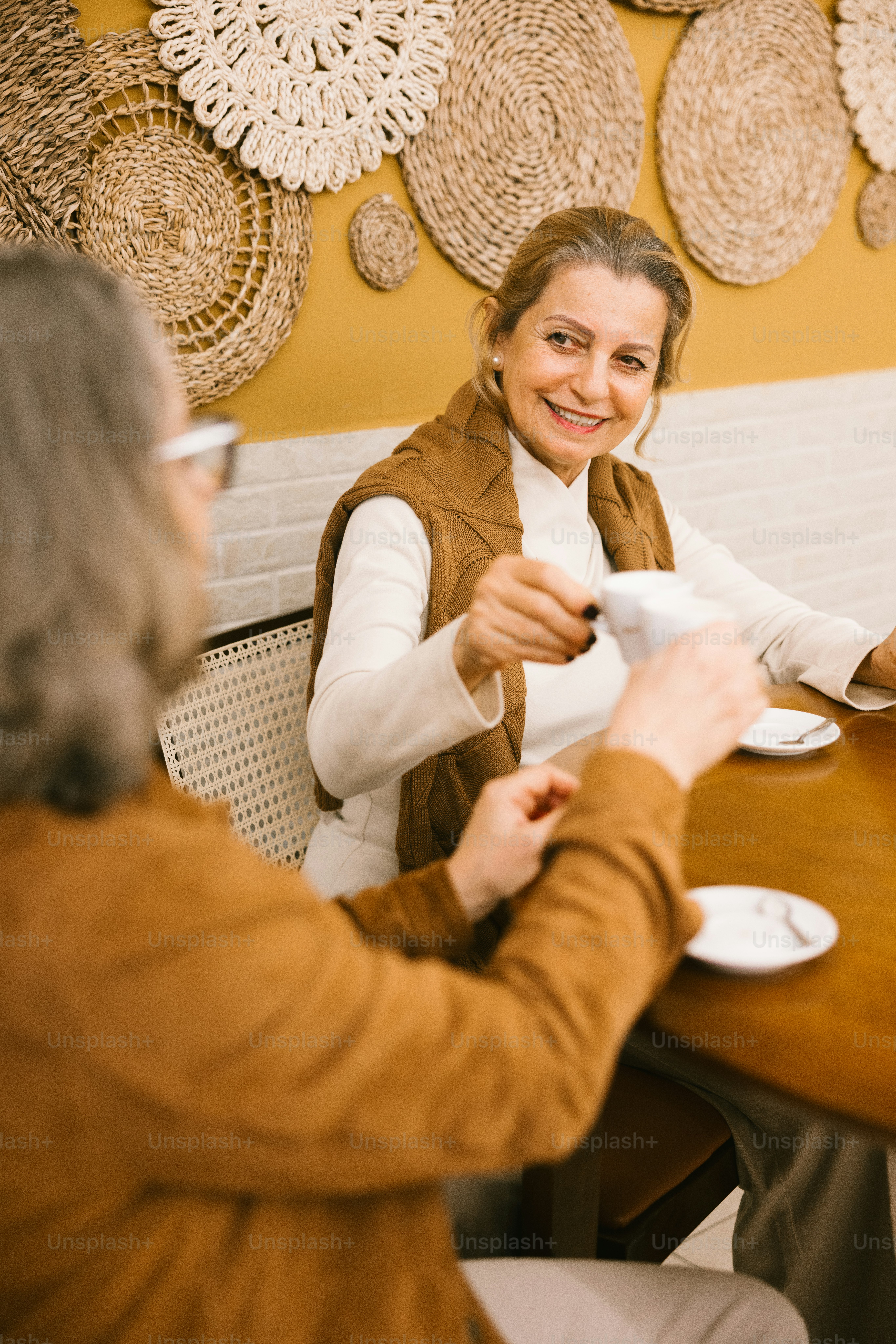 Two women share coffee at a table.