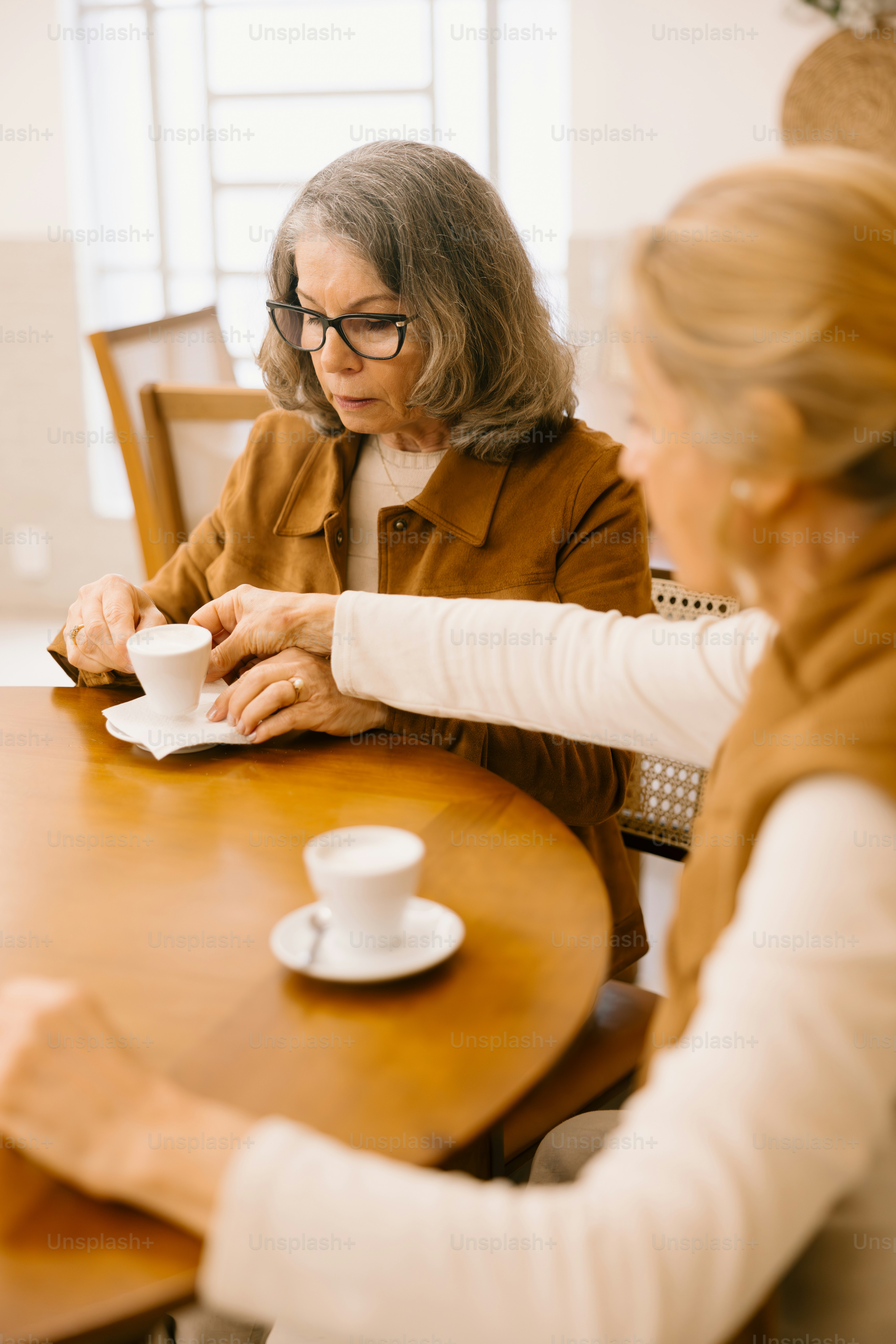 Two older women enjoying coffee together.