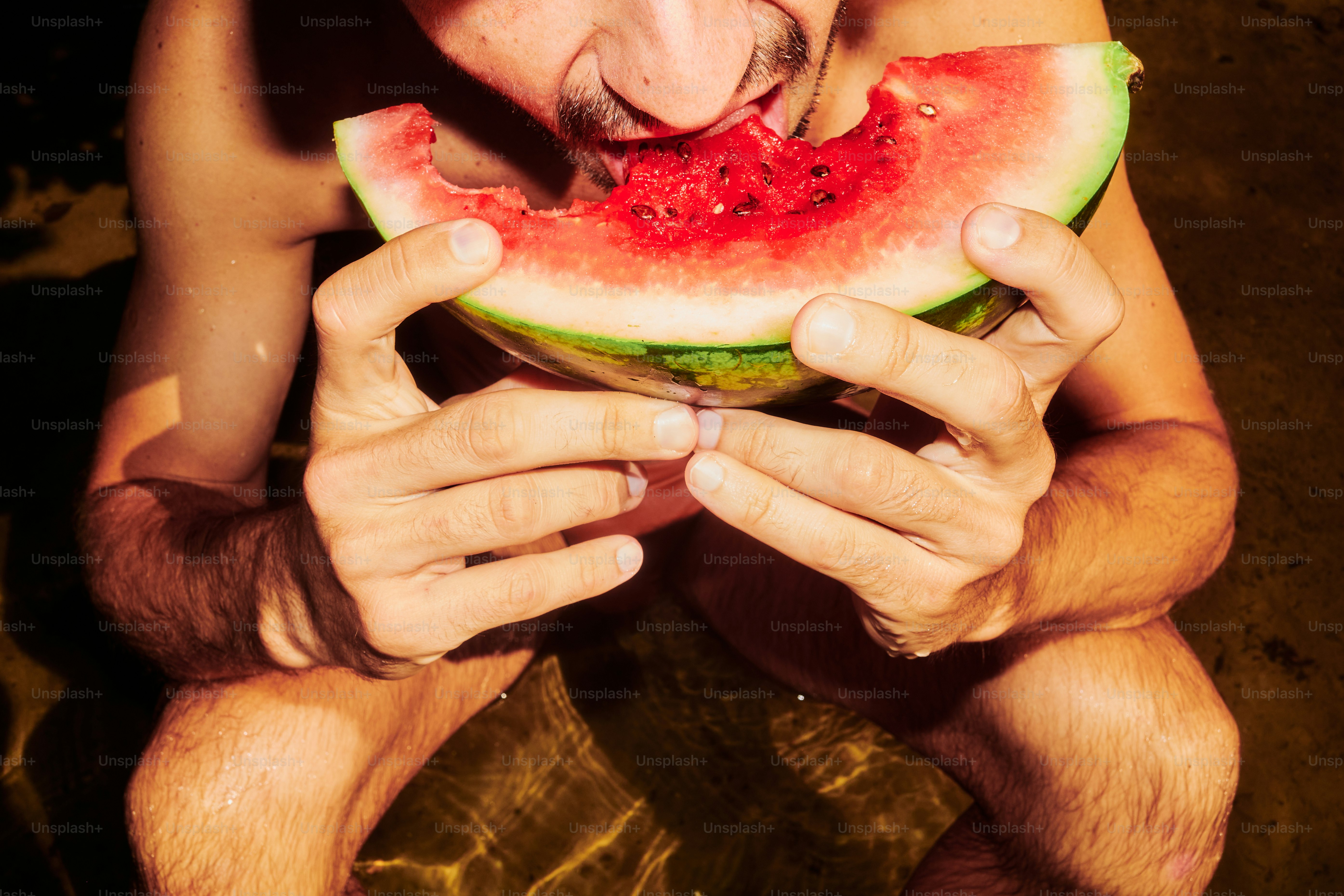 Der Mann genießt eine saftige Scheibe Wassermelone.