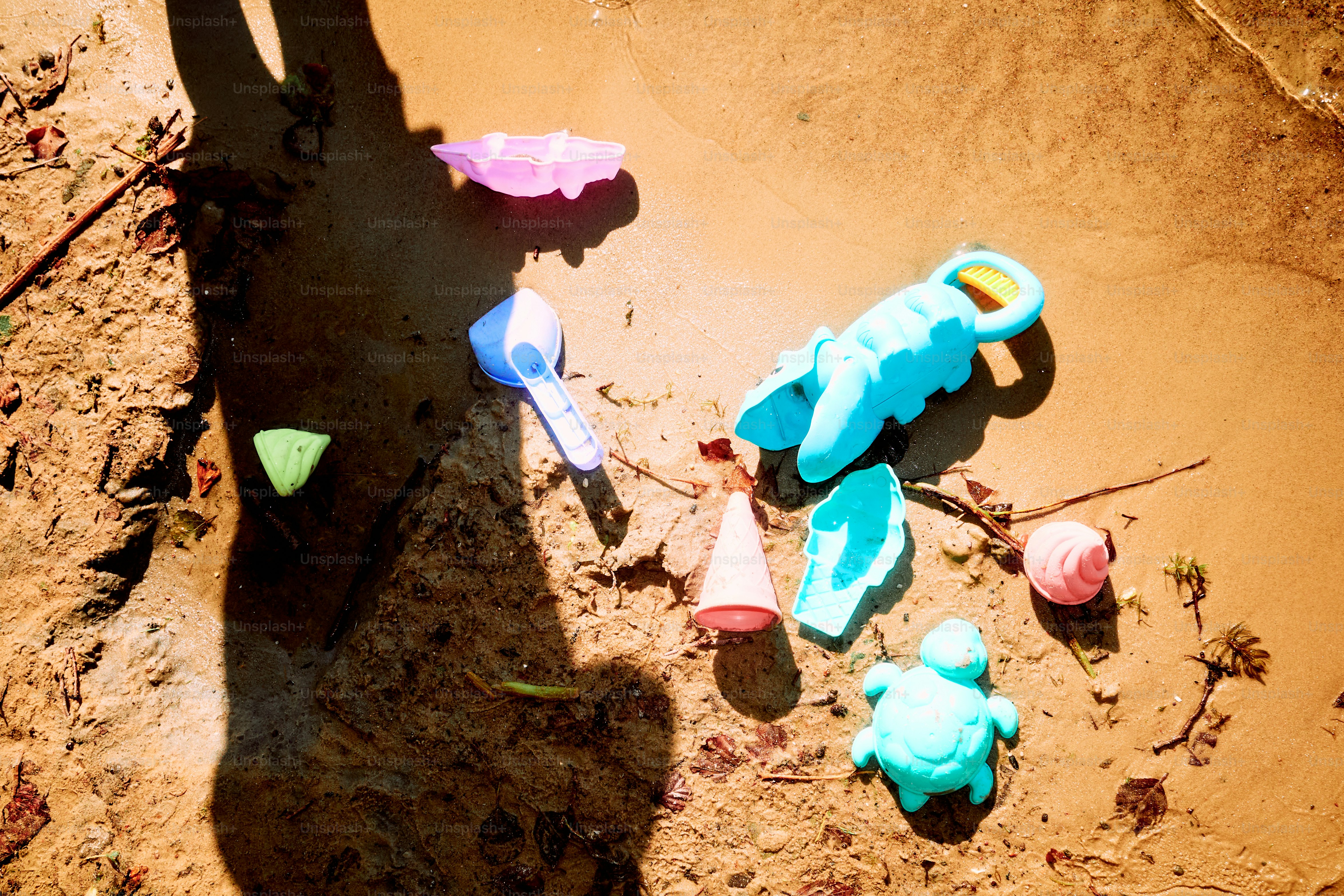 Strandspielzeug liegt verstreut im Sand.