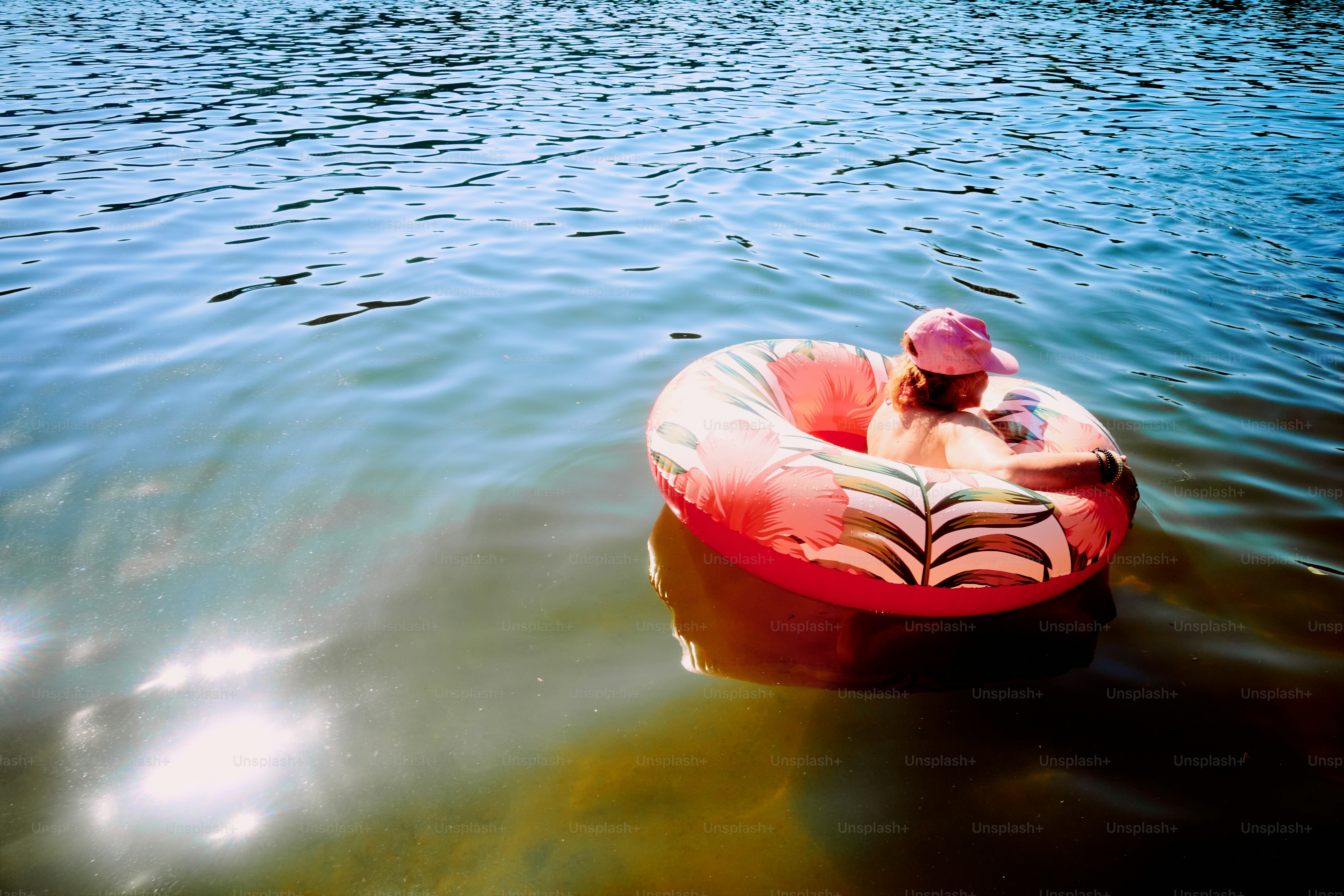 Die Person schwimmt auf einem Schlauch im Wasser.