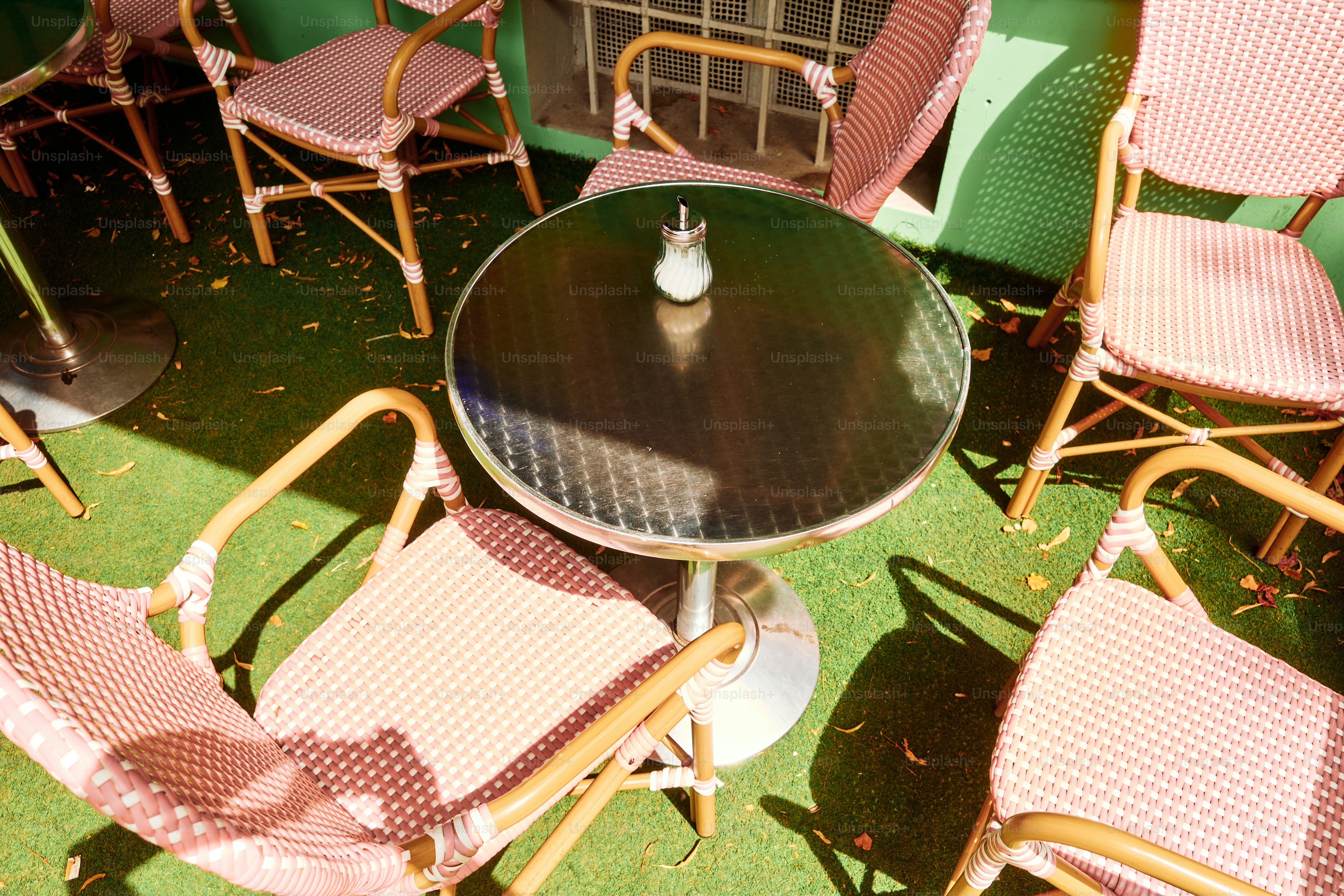 Cafétisch im Freien, umgeben von Stühlen.