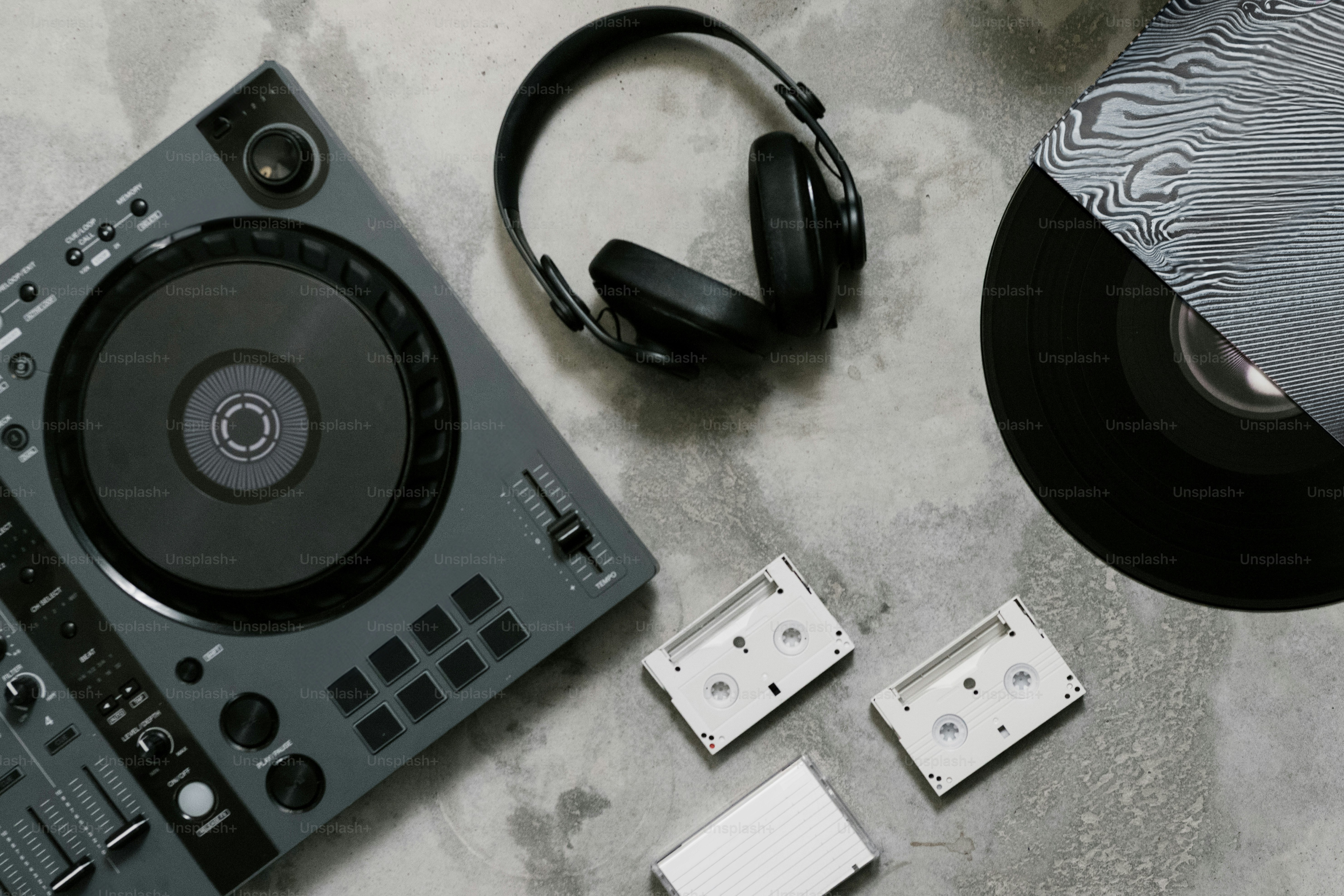 Dj equipment with vinyl, headphones, and cassettes.