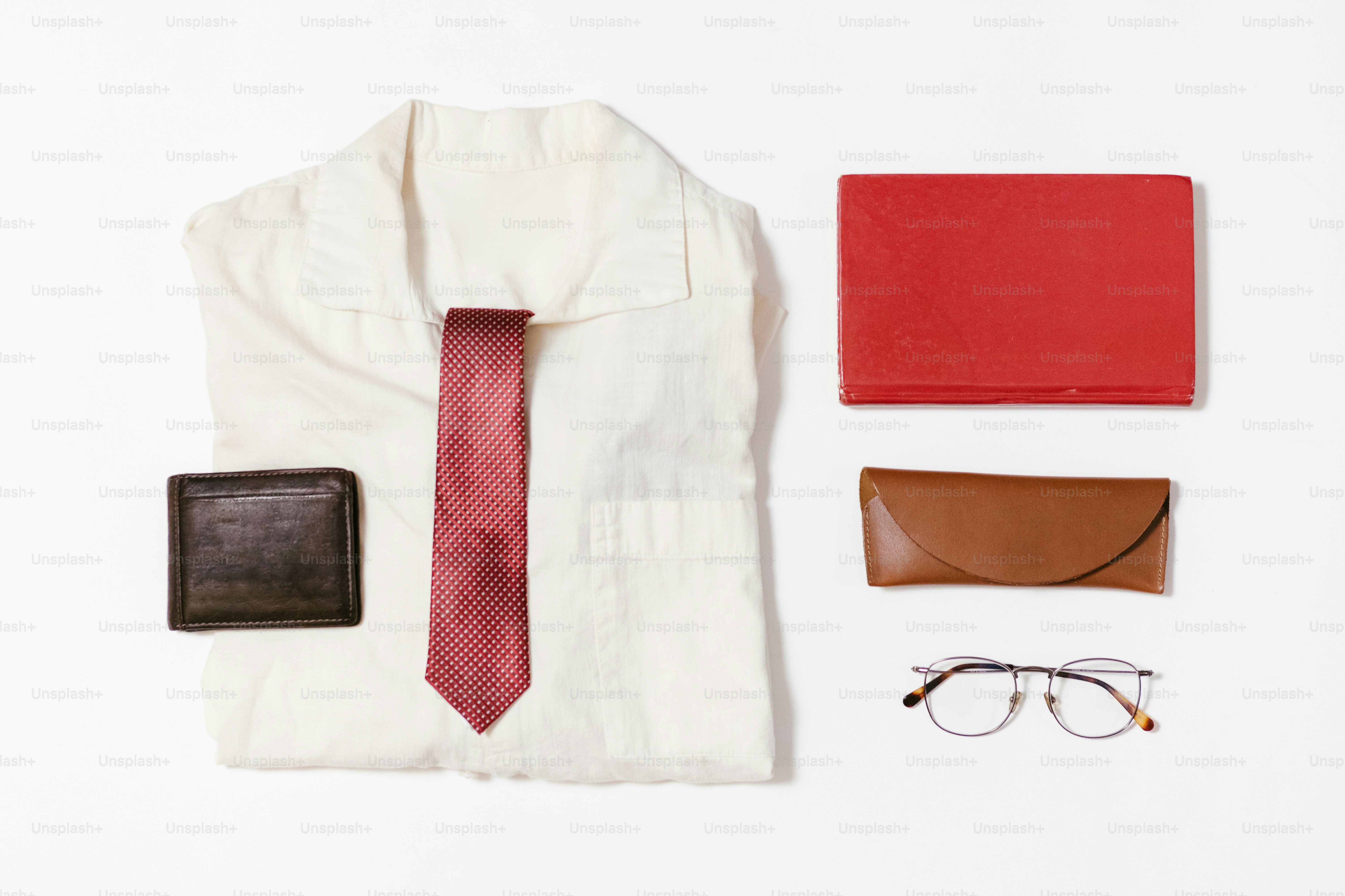 Formal attire and accessories arranged on white.